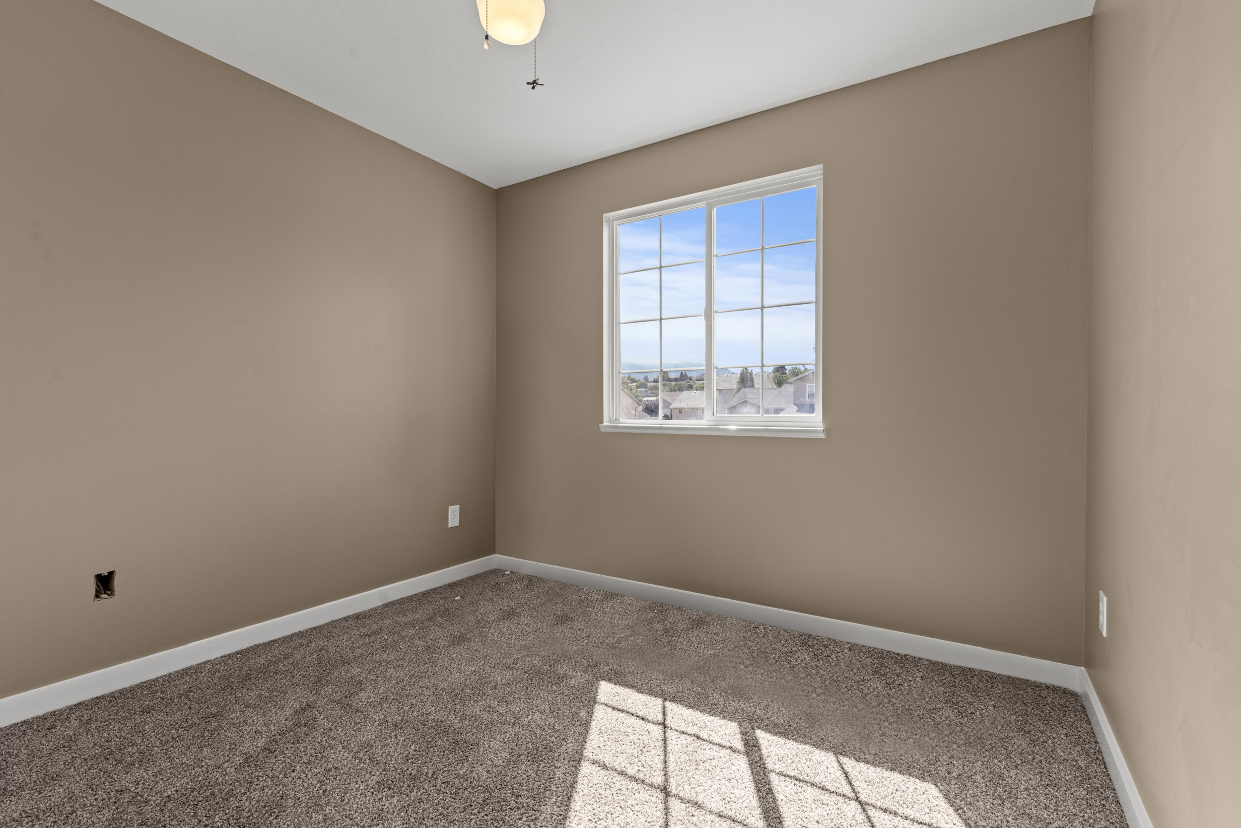 Interior room featuring neutral-toned walls, white trim, and plush carpet flooring