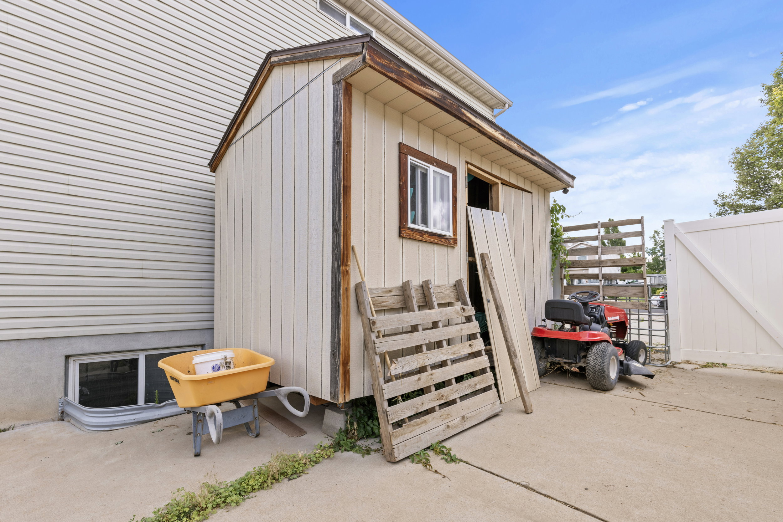 Detached utility shed with a pitched roof, a single window, and board-and-batten siding