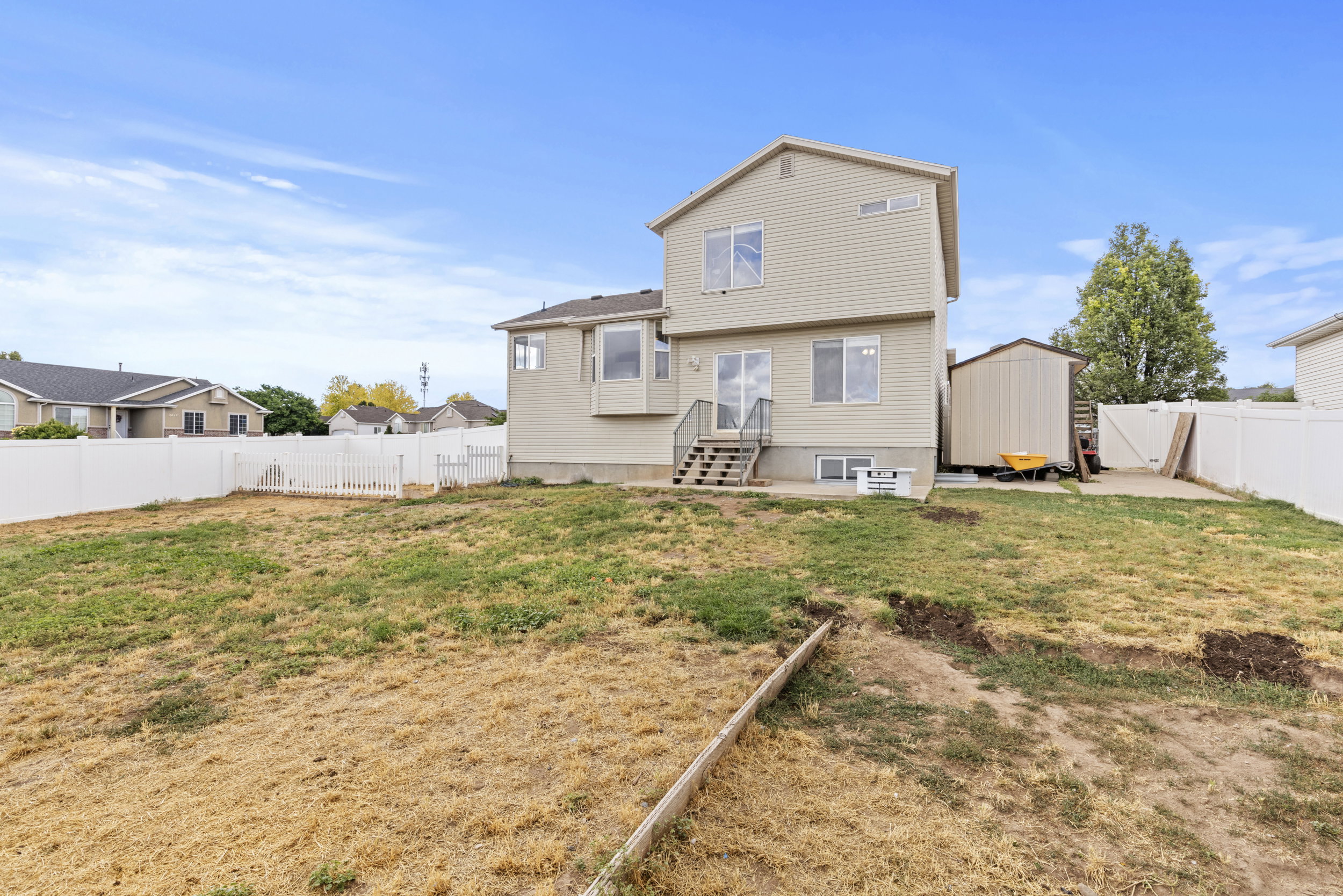 Expansive rear yard featuring a multi-level house exterior with a walk-out basement