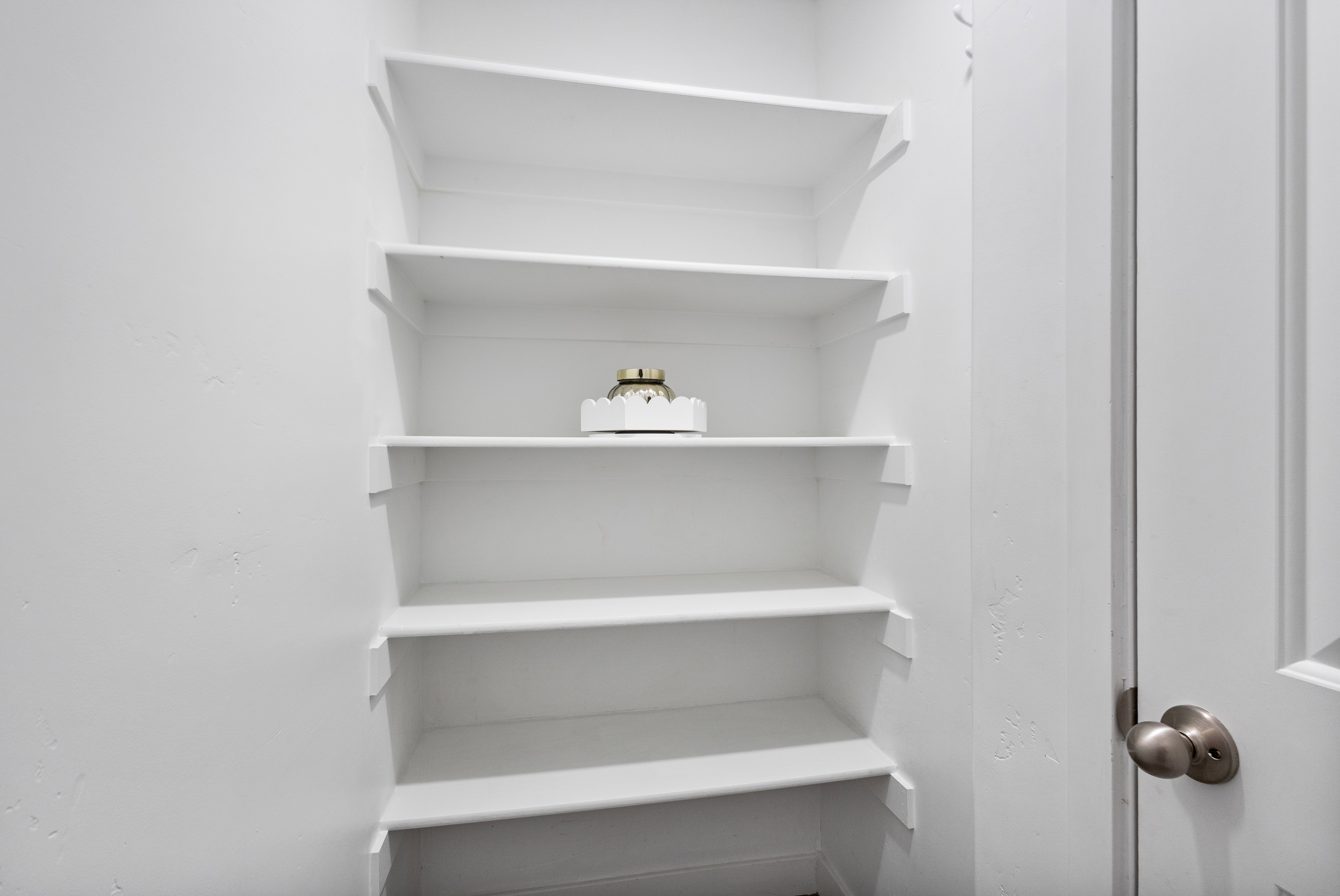 Built-in shelving unit with five white shelves