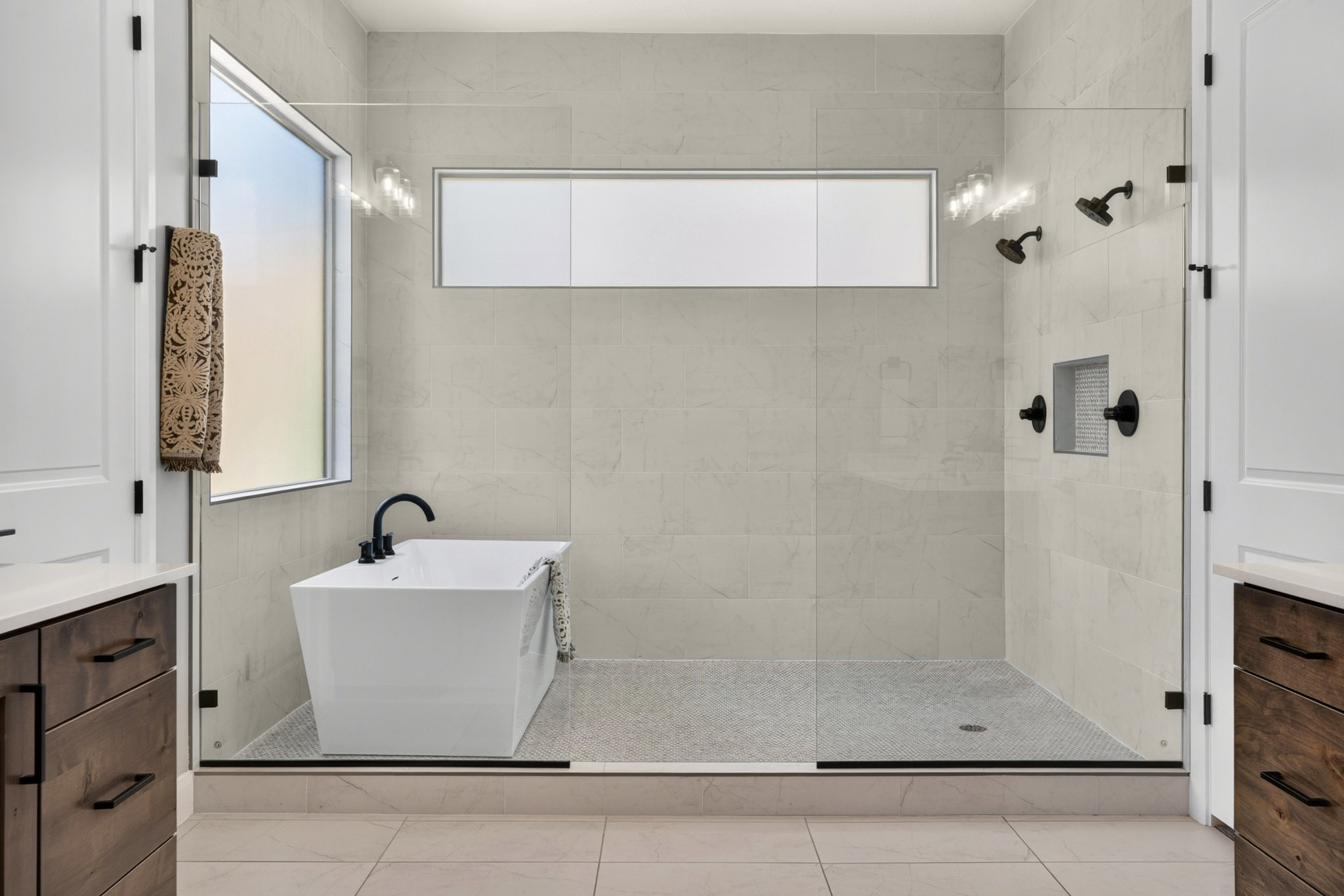 Spacious walk-in shower with a freestanding soaking tub, dual shower heads, and built-in shelving