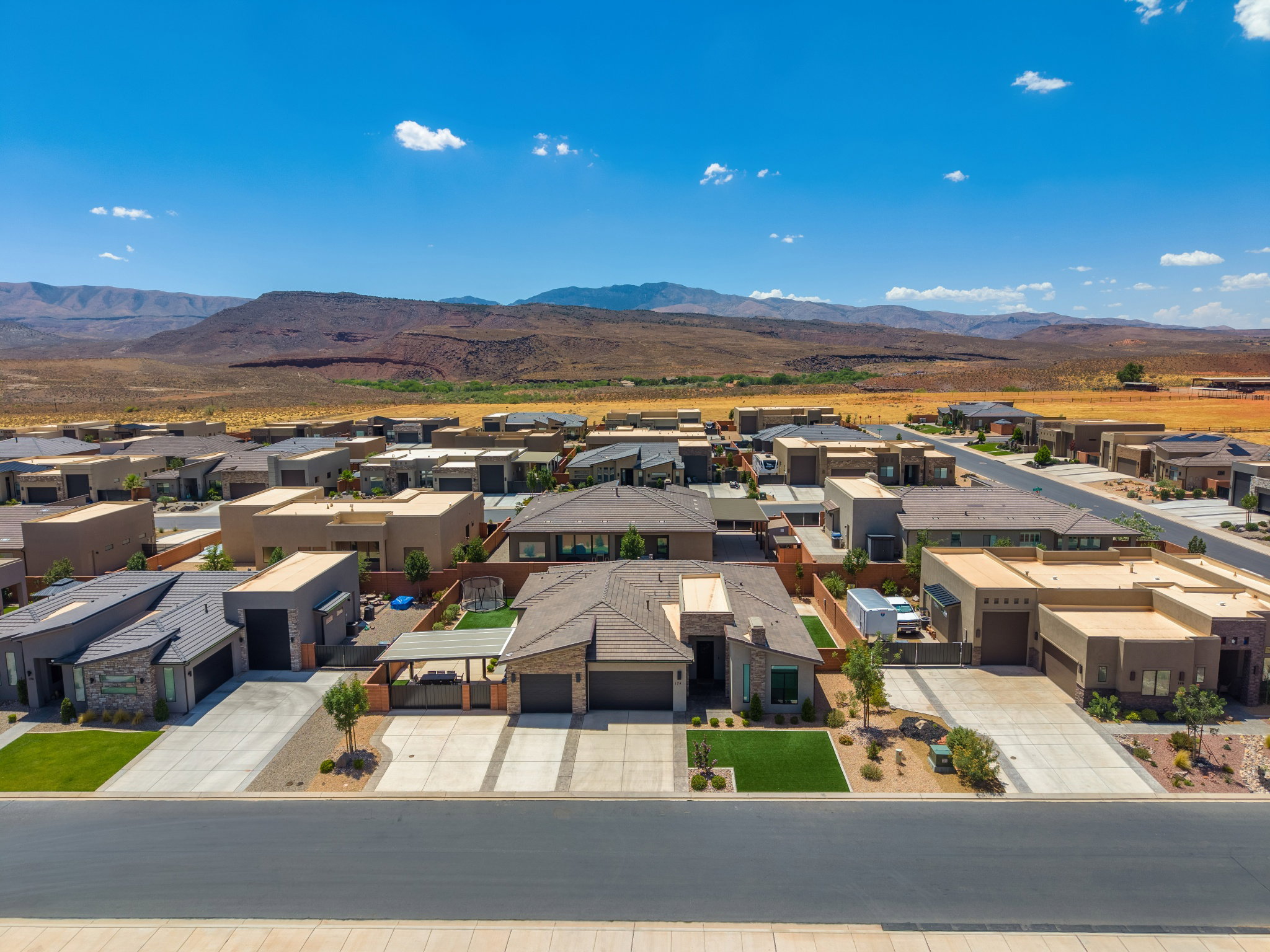 Modern desert community featuring a stucco and stone-clad residence with a two-car garage