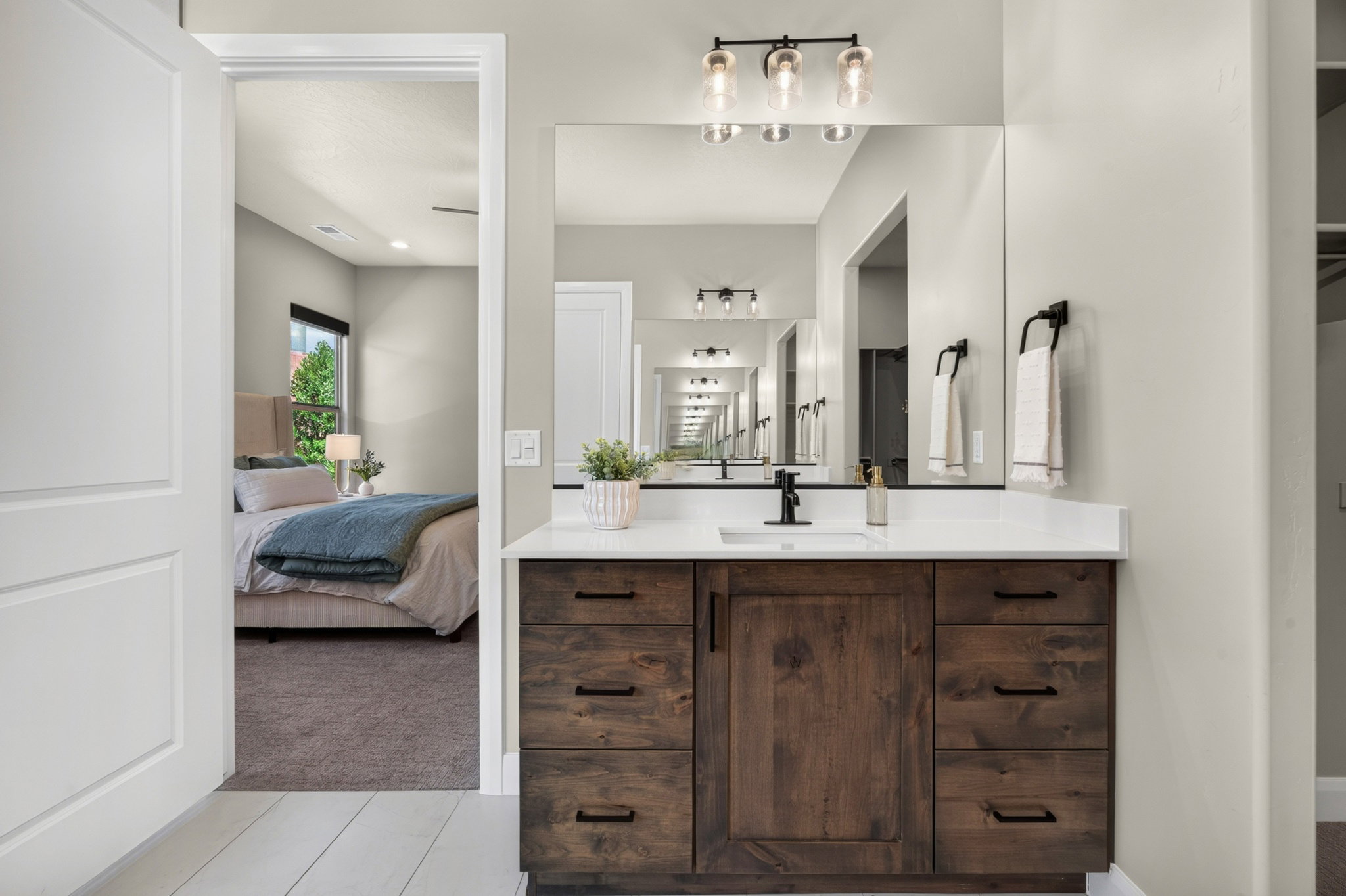 Vanity featuring a wood-finish cabinet, white countertop, and integrated rectangular sink with a matte black faucet