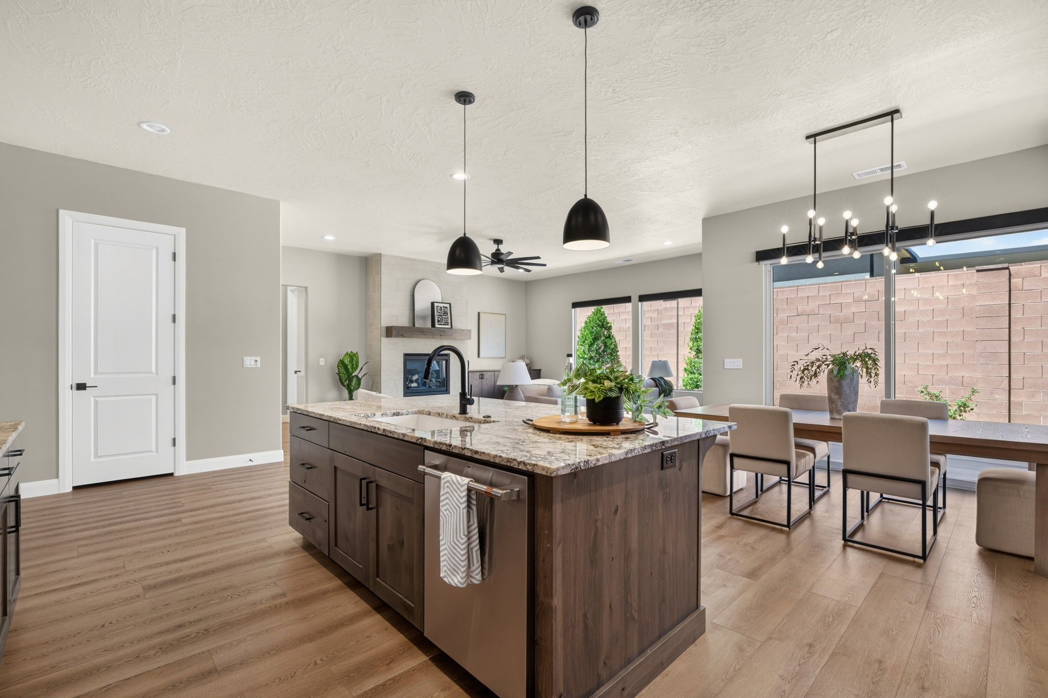 Spacious kitchen island with an integrated sink and dishwasher, featuring granite countertops and wood-finish cabinetry