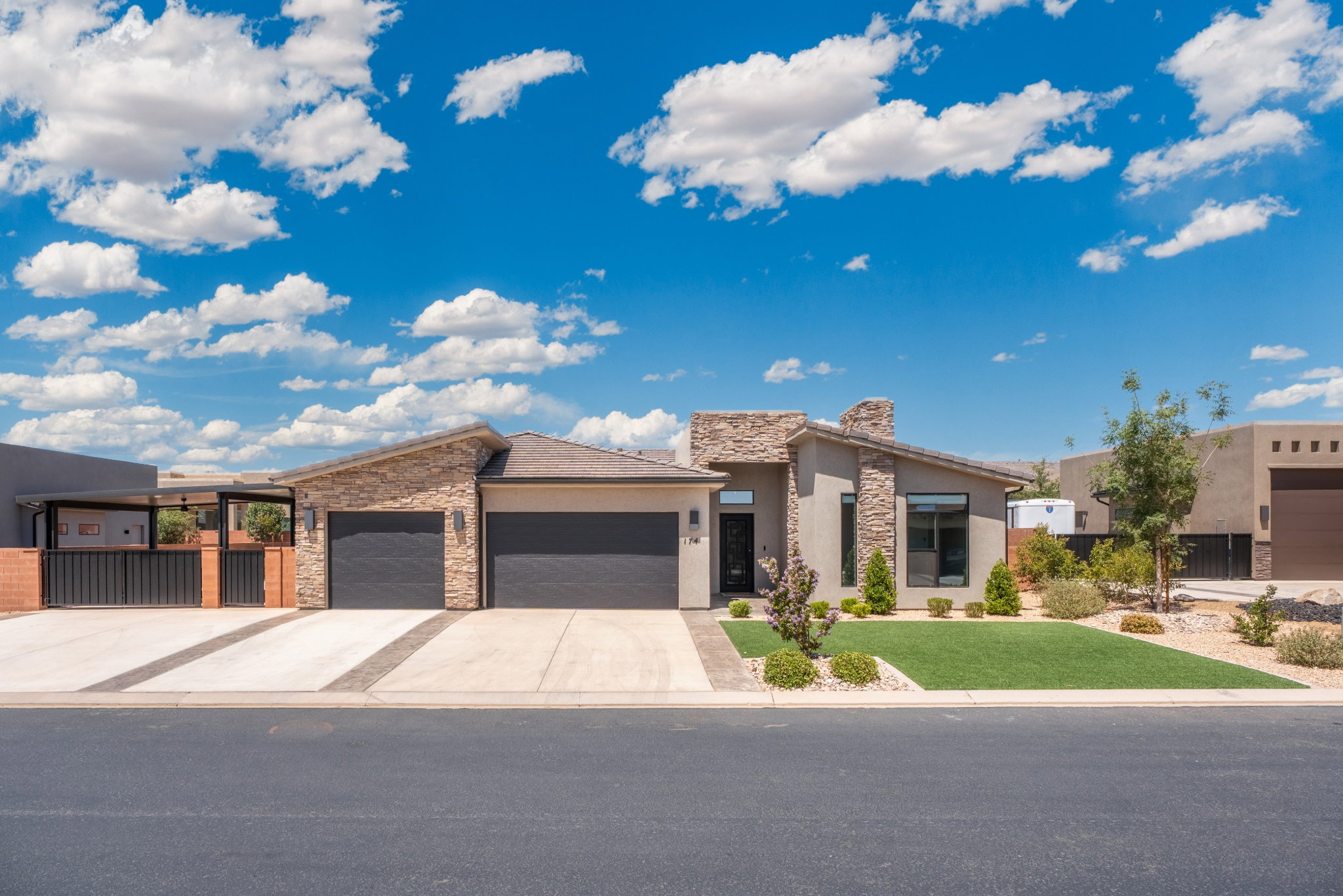 Modern stucco and stone-clad exterior with a pitched roofline