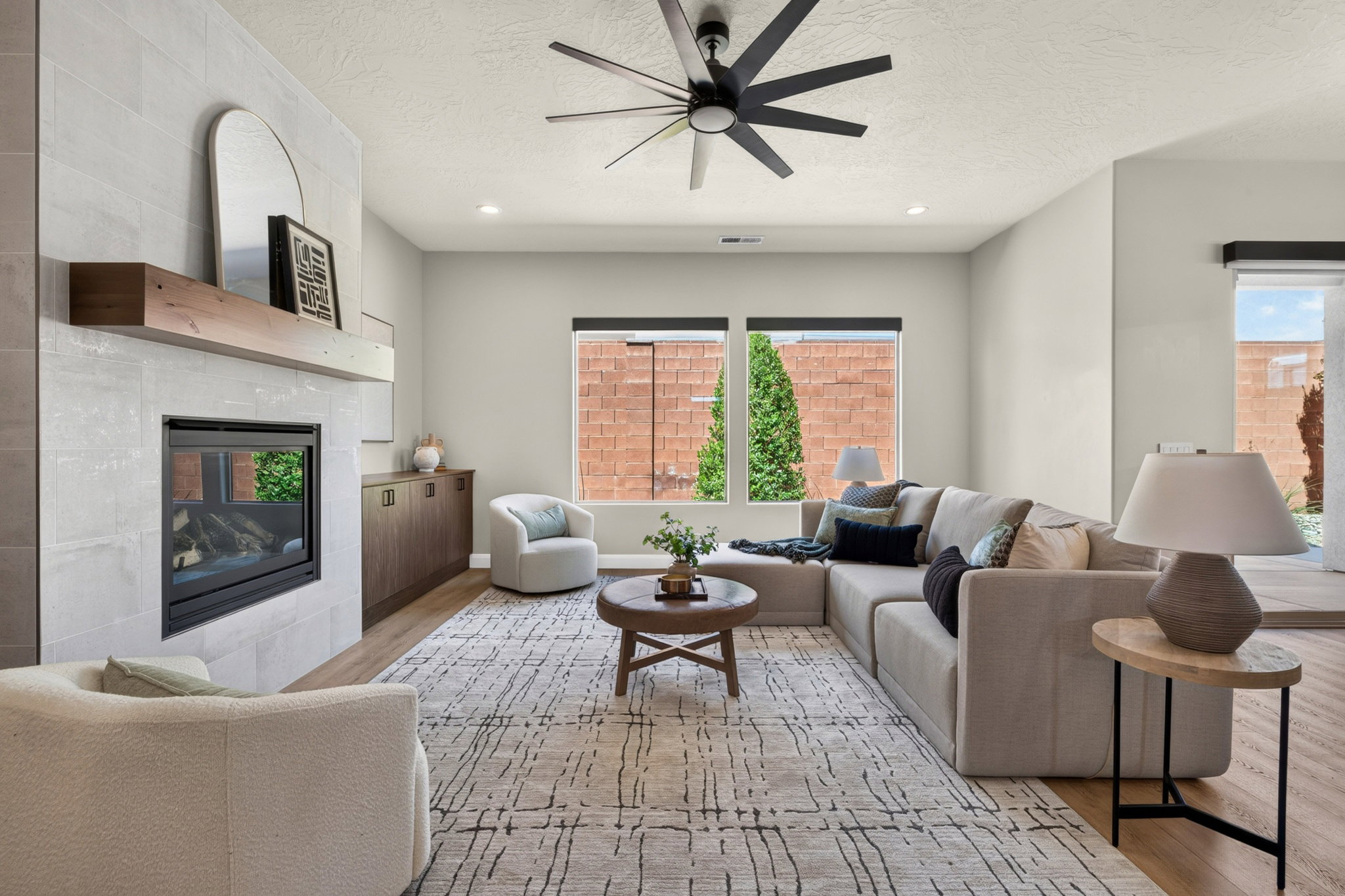 Living area featuring a modern fireplace with a light-toned tile surround and a wood mantel
