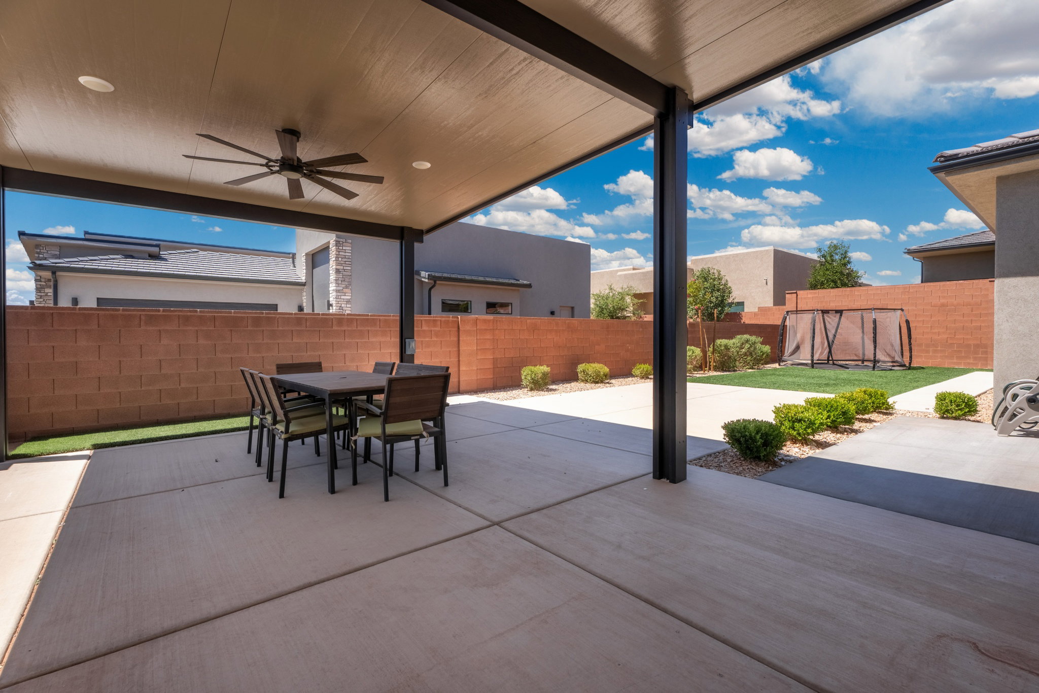 Covered patio with recessed lighting and a ceiling fan, featuring a large concrete surface