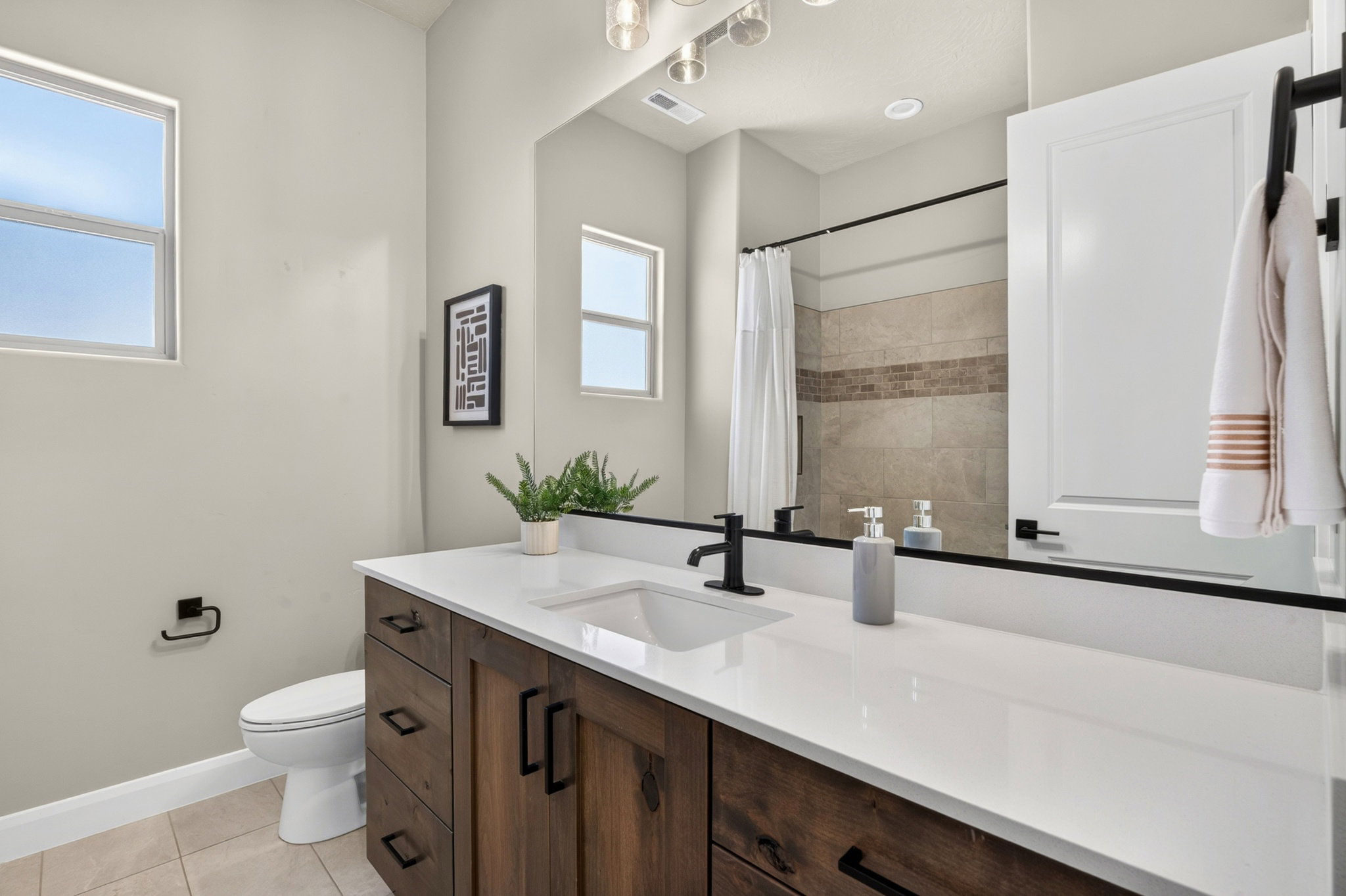 Bathroom featuring a wood-finish vanity with a white countertop and integrated sink