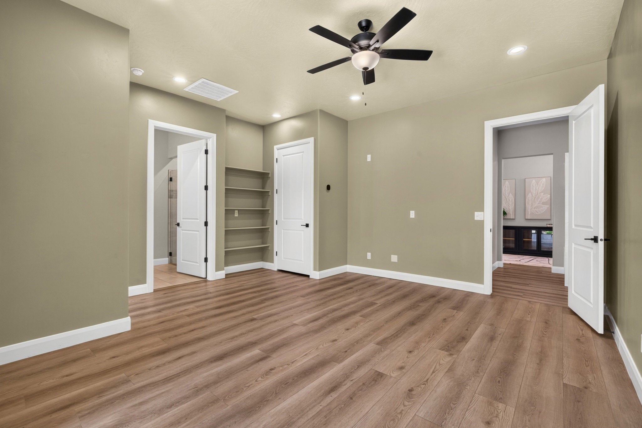 Spacious room featuring wood-finish flooring, recessed lighting, and a ceiling fan