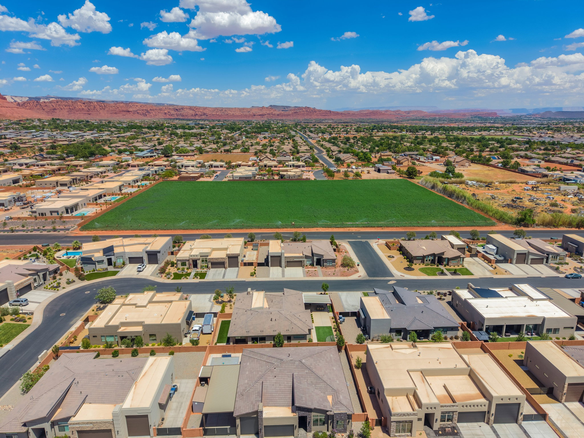 Aerial perspective showcasing residential development against a backdrop of distant red rock formations