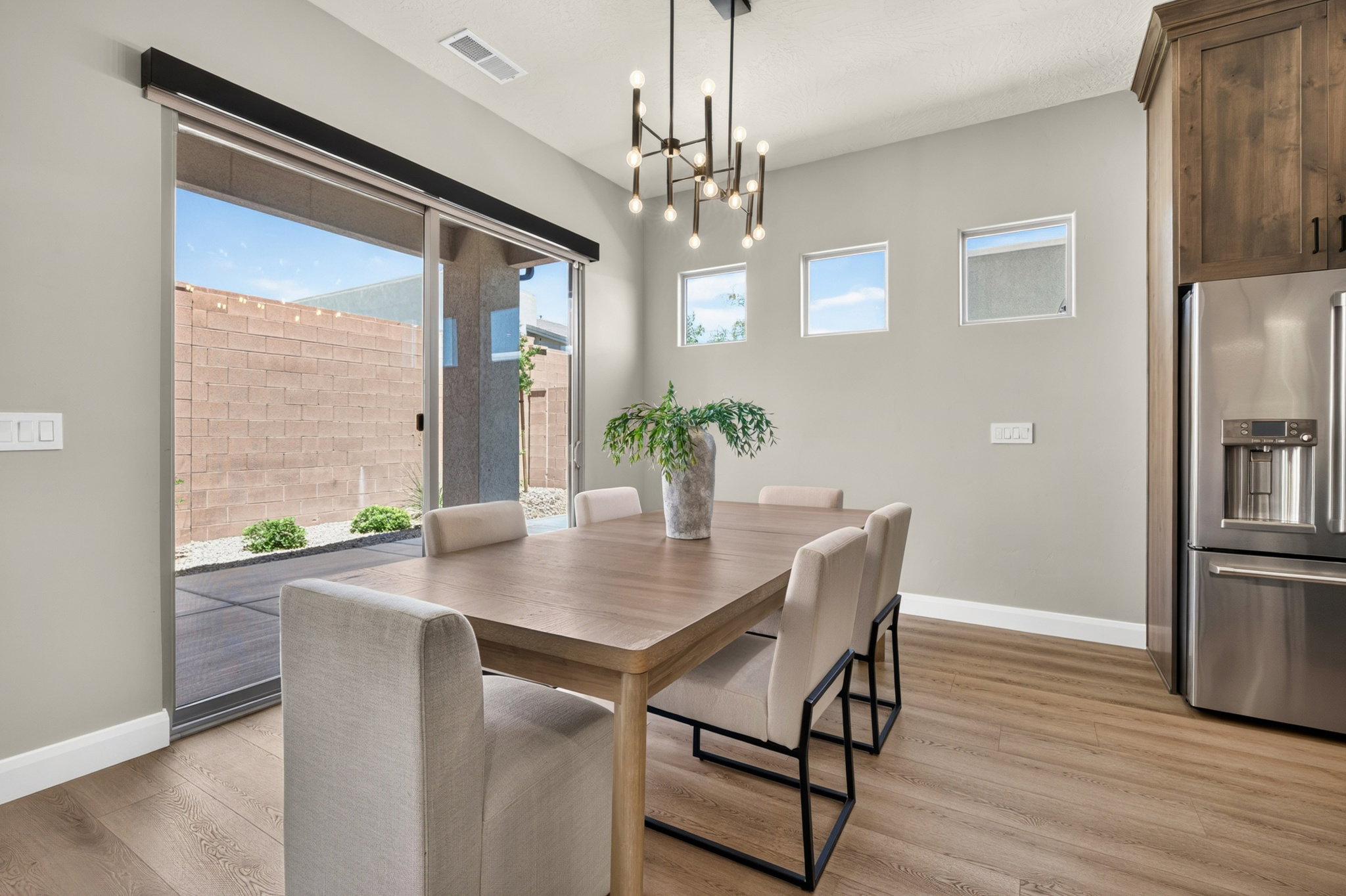 Dining area featuring wood-finish flooring, a contemporary chandelier, and a sliding glass door