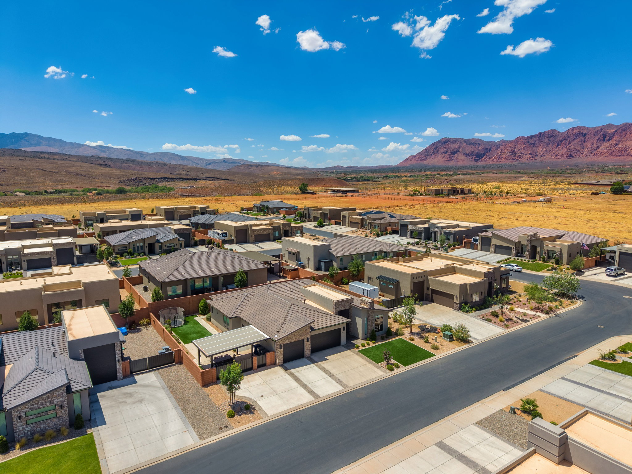 Modern desert community featuring single-story residences with stucco and stone exteriors, integrated garages, and low-maintenance landscaping