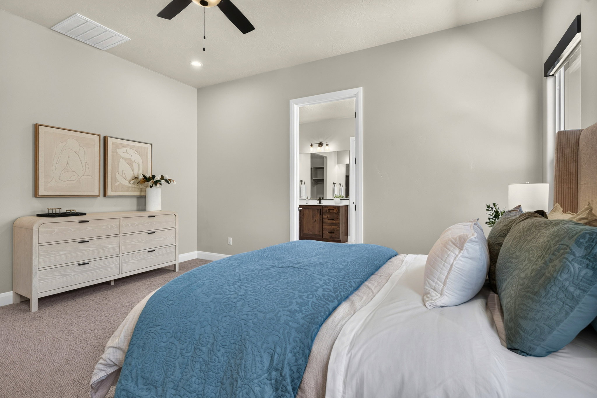 Spacious bedroom featuring light-toned carpeting and a neutral wall color