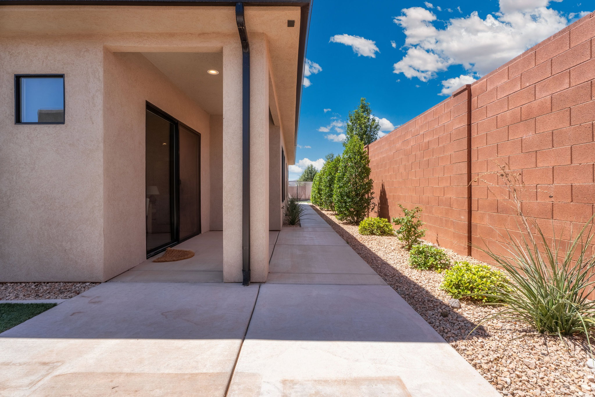 Stucco exterior featuring a covered patio with sliding glass door access