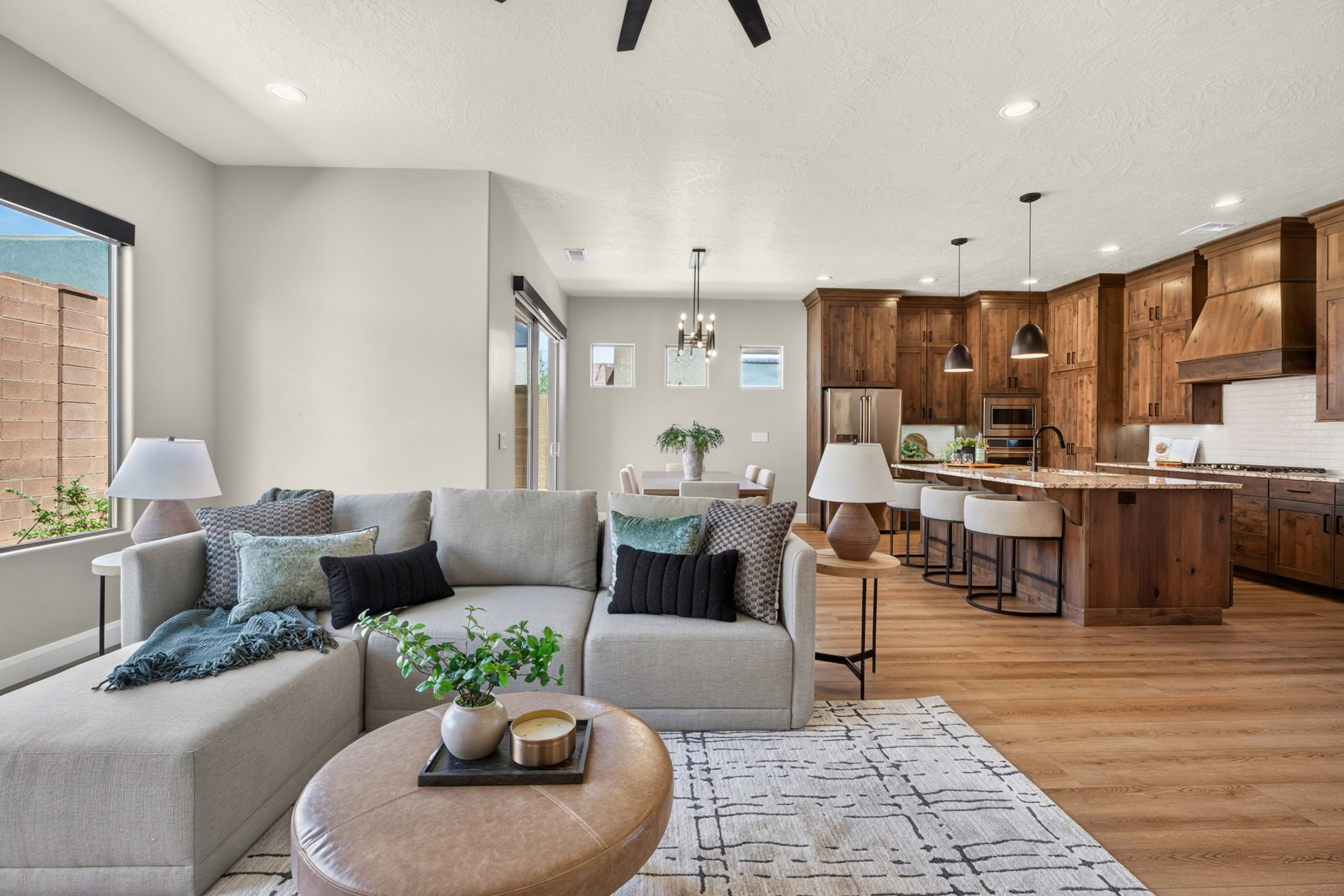 Open-concept living space featuring wood-finish flooring, recessed lighting, and a neutral color palette