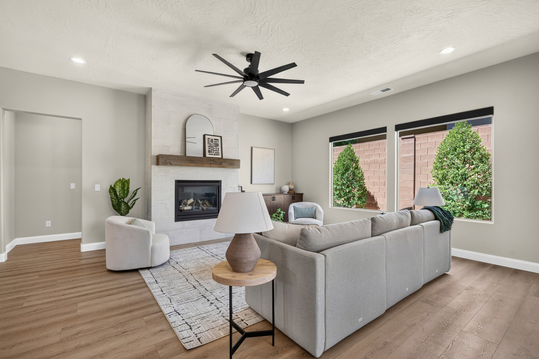 Living area featuring wood-finish flooring, a contemporary ceiling fan, and recessed lighting