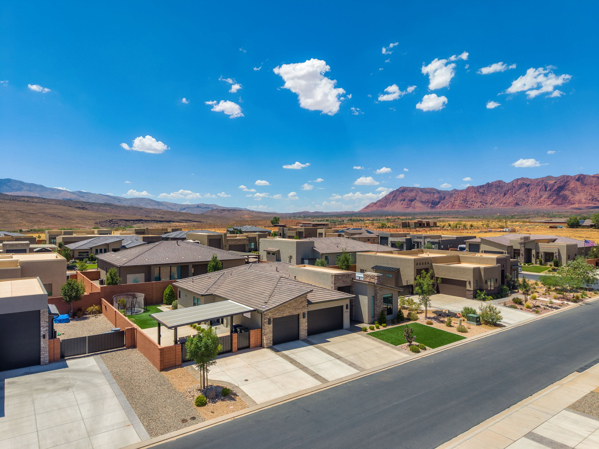 Expansive residential development featuring contemporary architecture with flat and low-slope roofs, integrated garages, and desert-adapted landscaping
