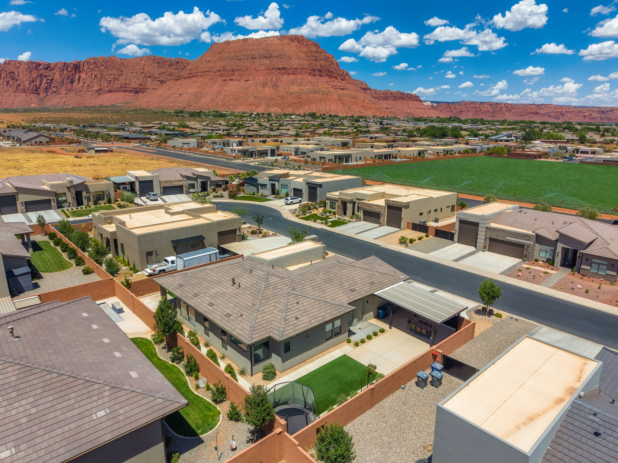 Aerial perspective showcasing a residential community with a striking red rock mountain backdrop