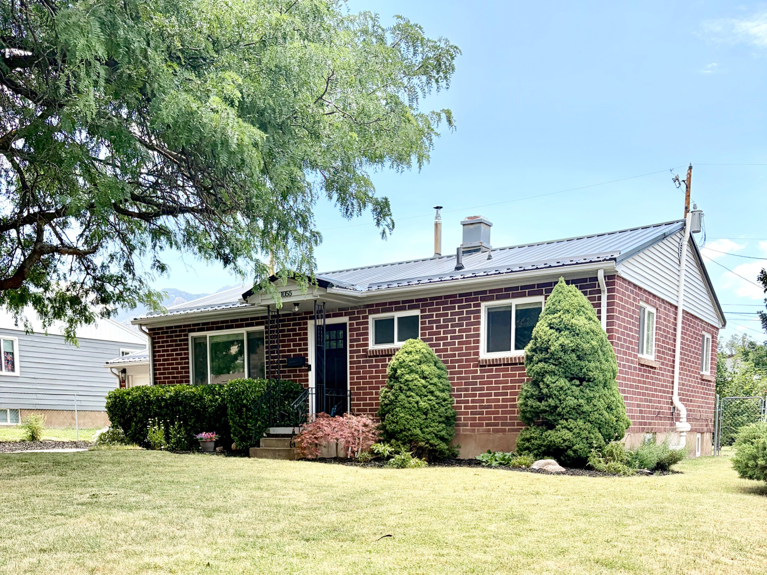 Red brick exterior with white trim windows and a dark metal roof