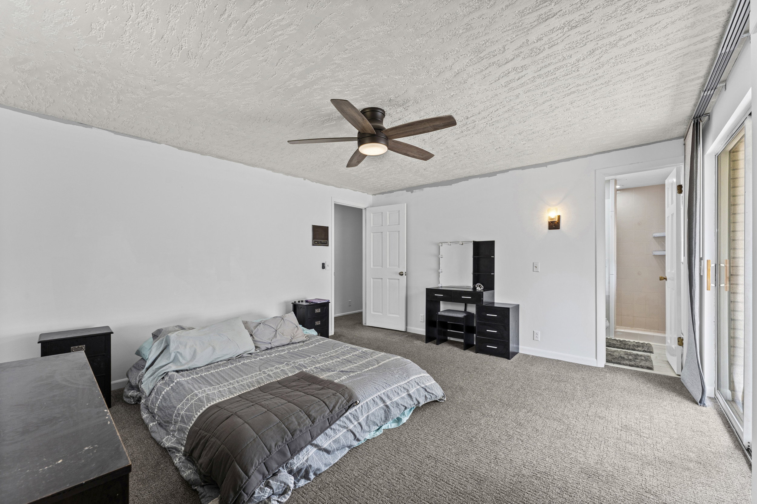 Bedroom featuring neutral carpeting, a ceiling fan, and white walls
