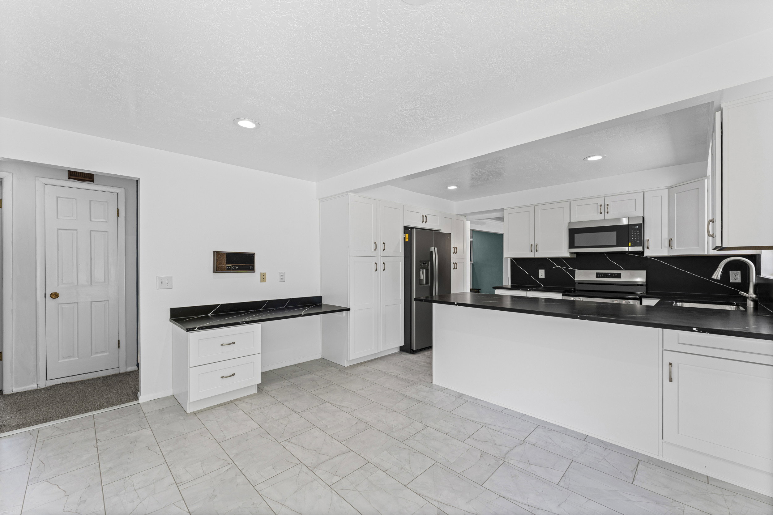 Bright kitchen with white cabinetry and black countertops