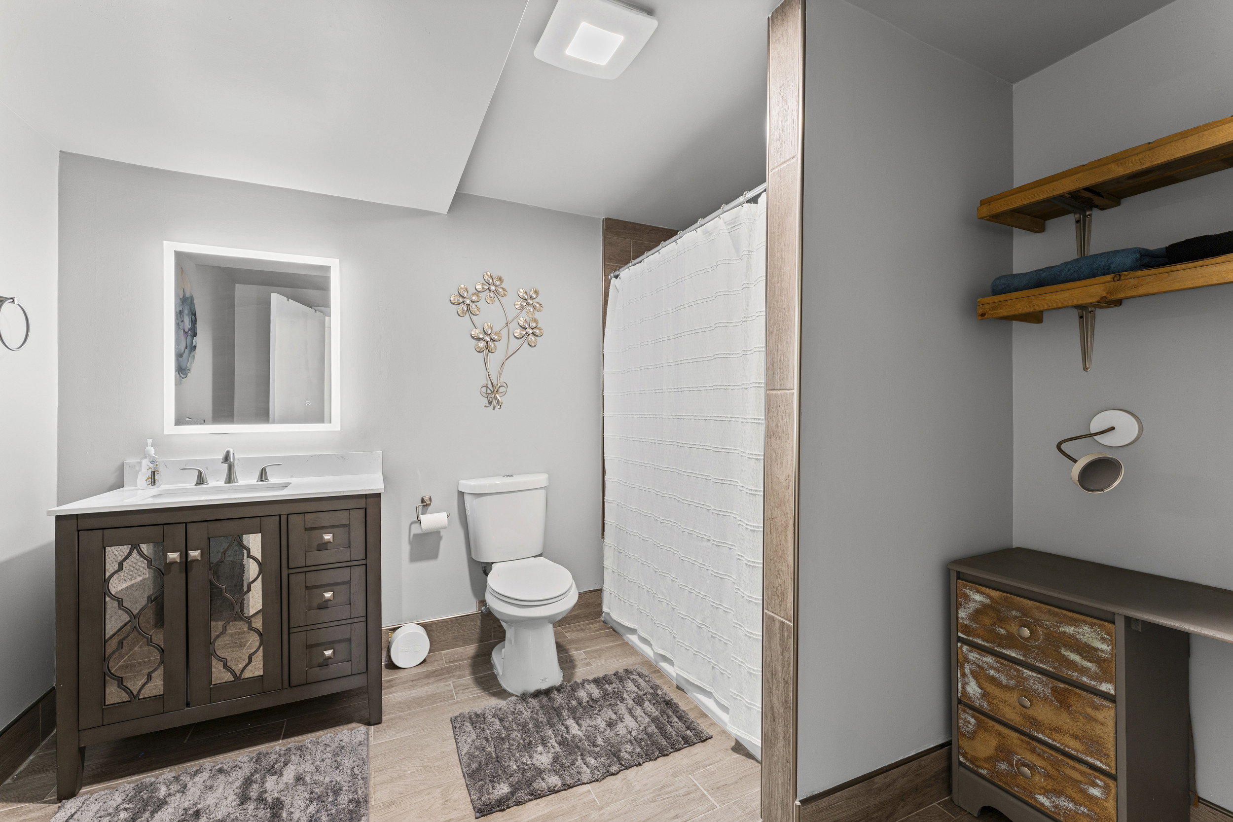 Bathroom featuring a dark wood-finish vanity with a white countertop and rectangular undermount sink