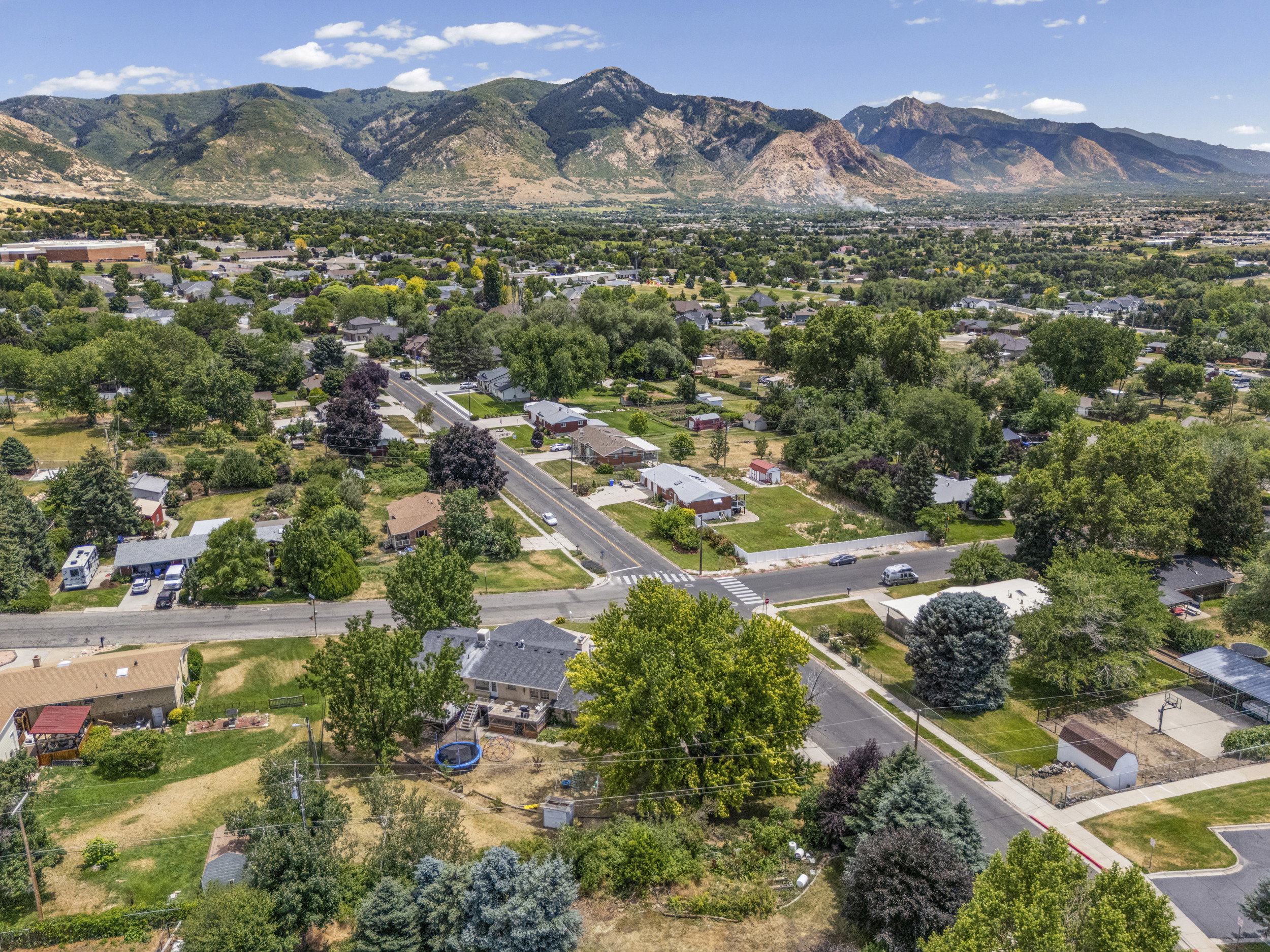 Panoramic mountain backdrop featuring a developed residential area with mature trees and established homes