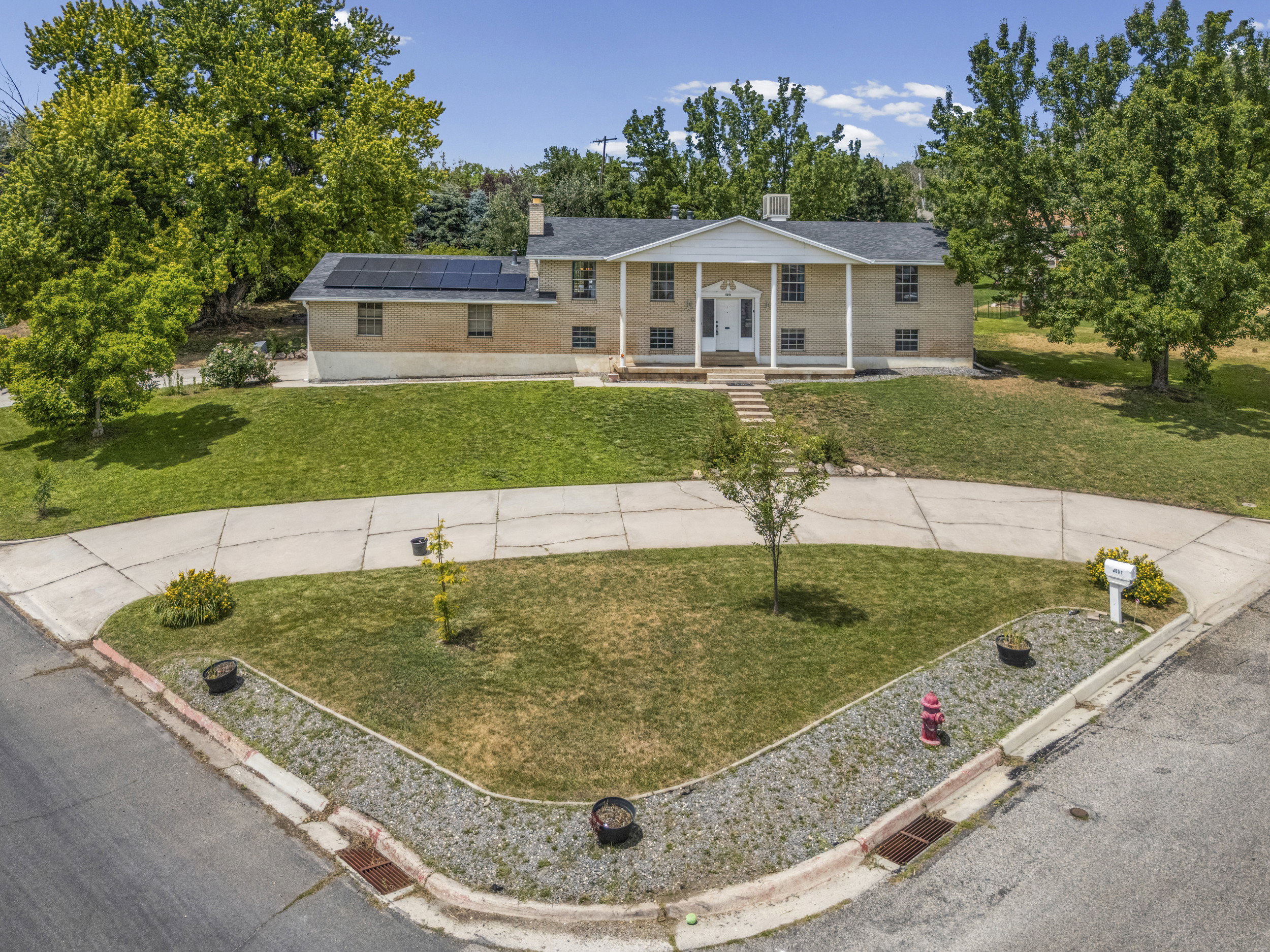 Traditional brick residence with a columned portico entry, a gabled roof, and multiple windows