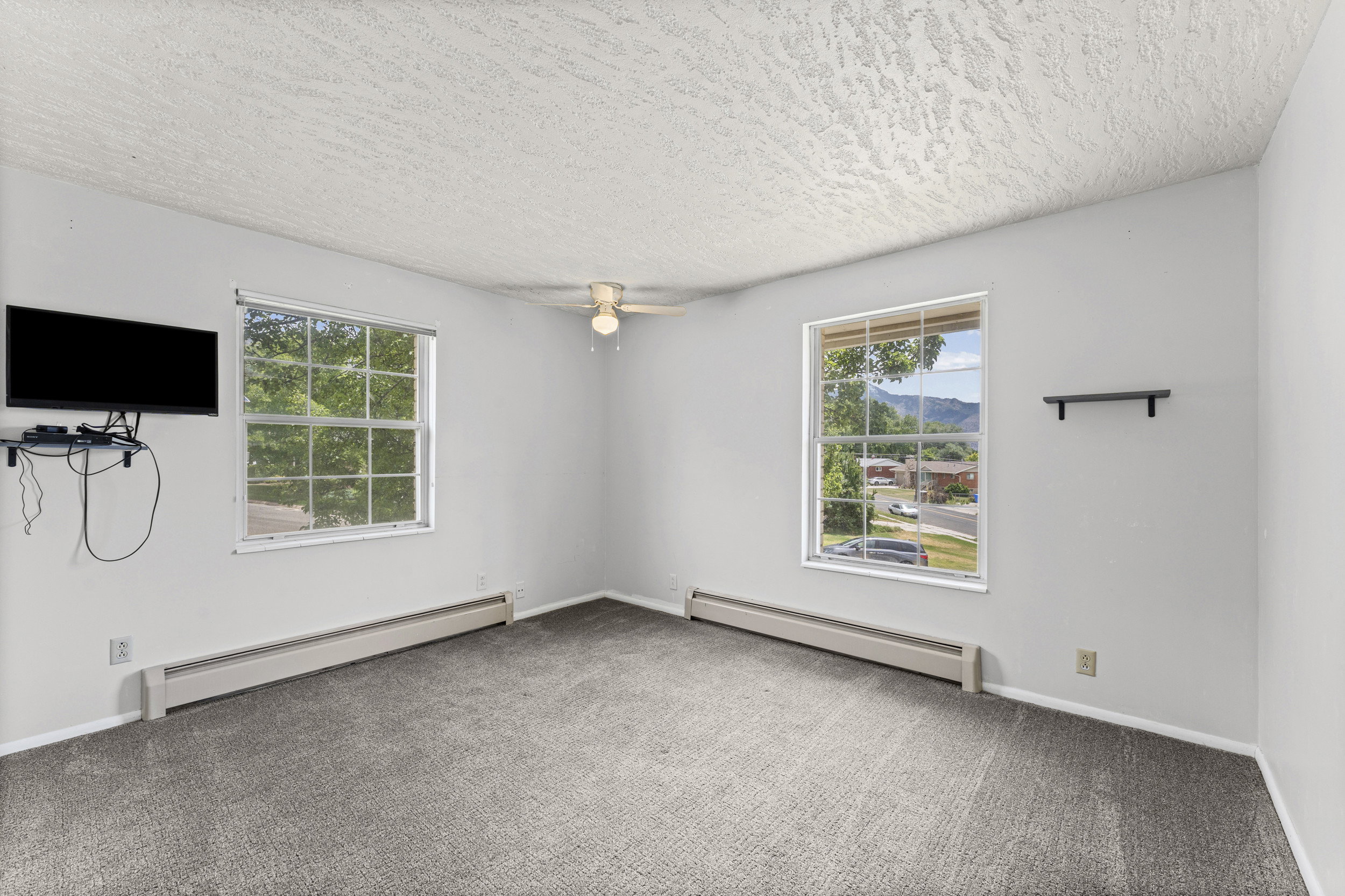 Carpeted interior space featuring light-colored walls and a textured ceiling