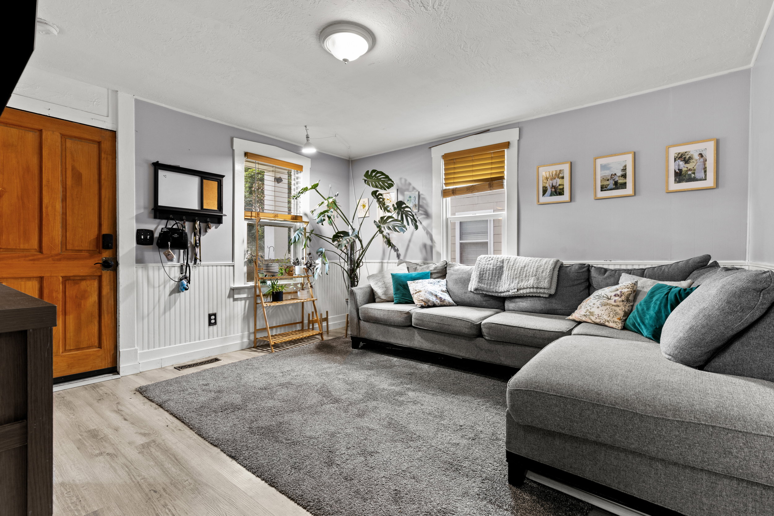 Living area featuring light wood-finish flooring, a neutral wall color, and white beadboard paneling