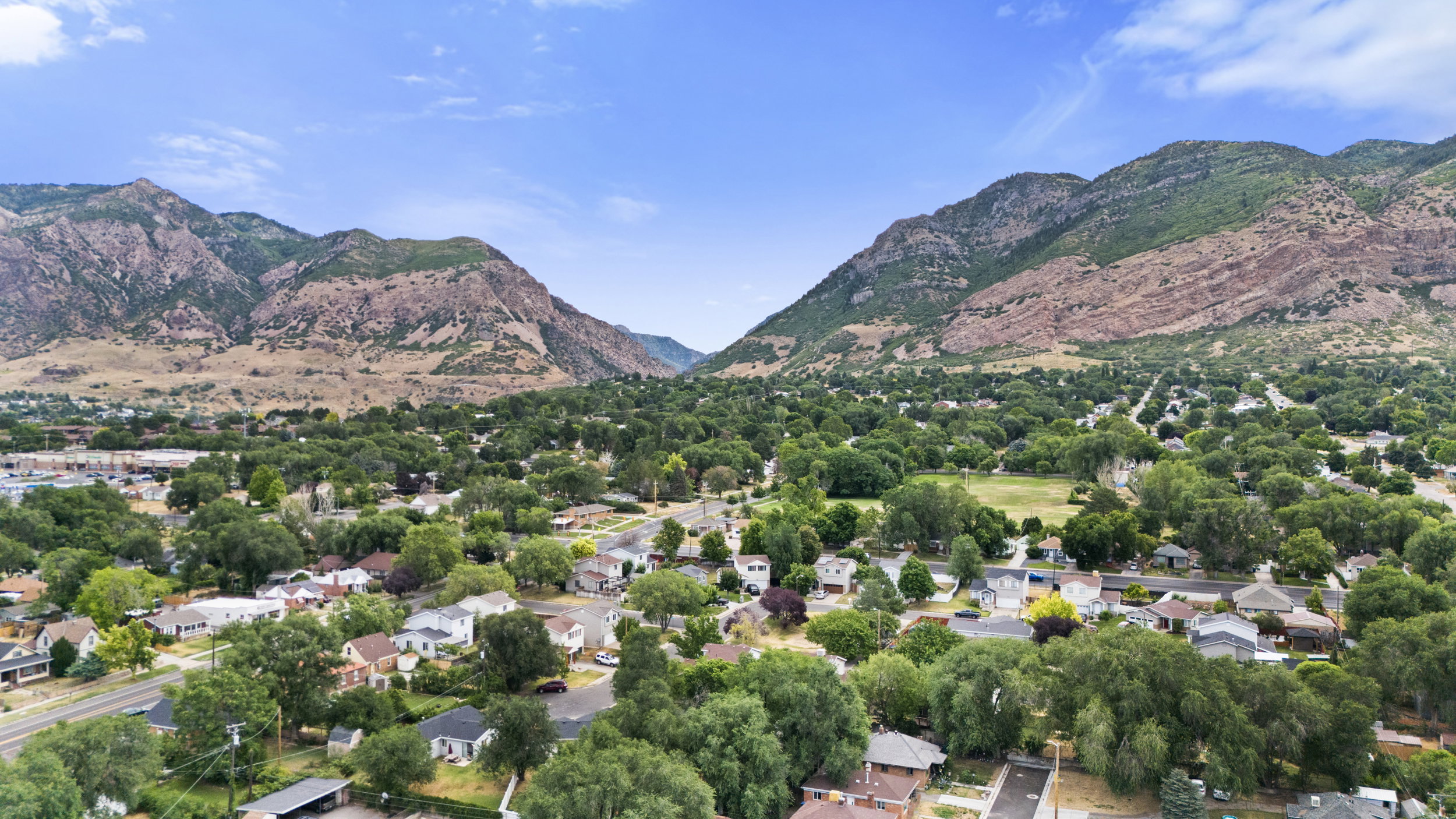 Expansive neighborhood framed by mountainous terrain and abundant mature trees