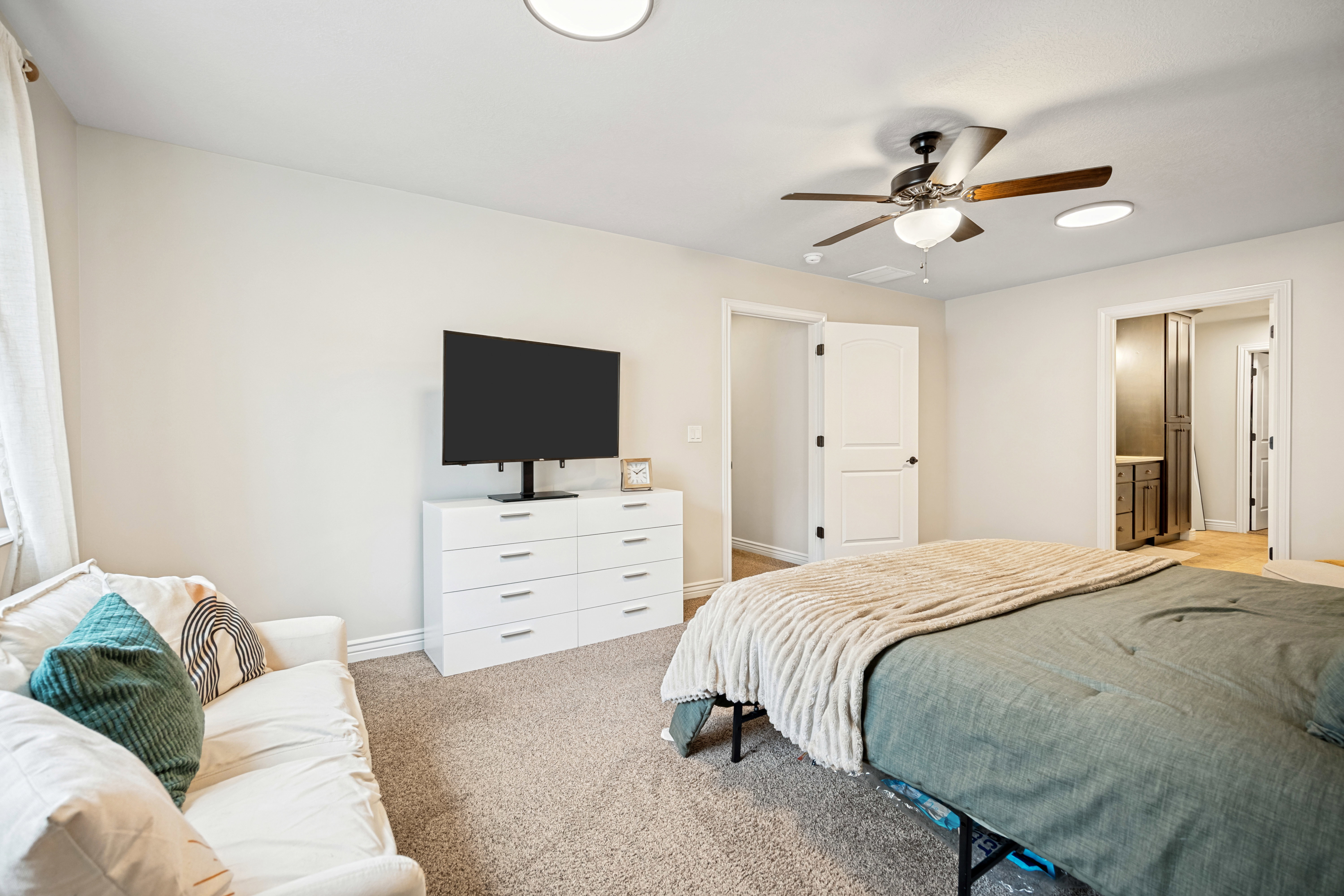 Carpeted room with light-colored walls and ceiling fan