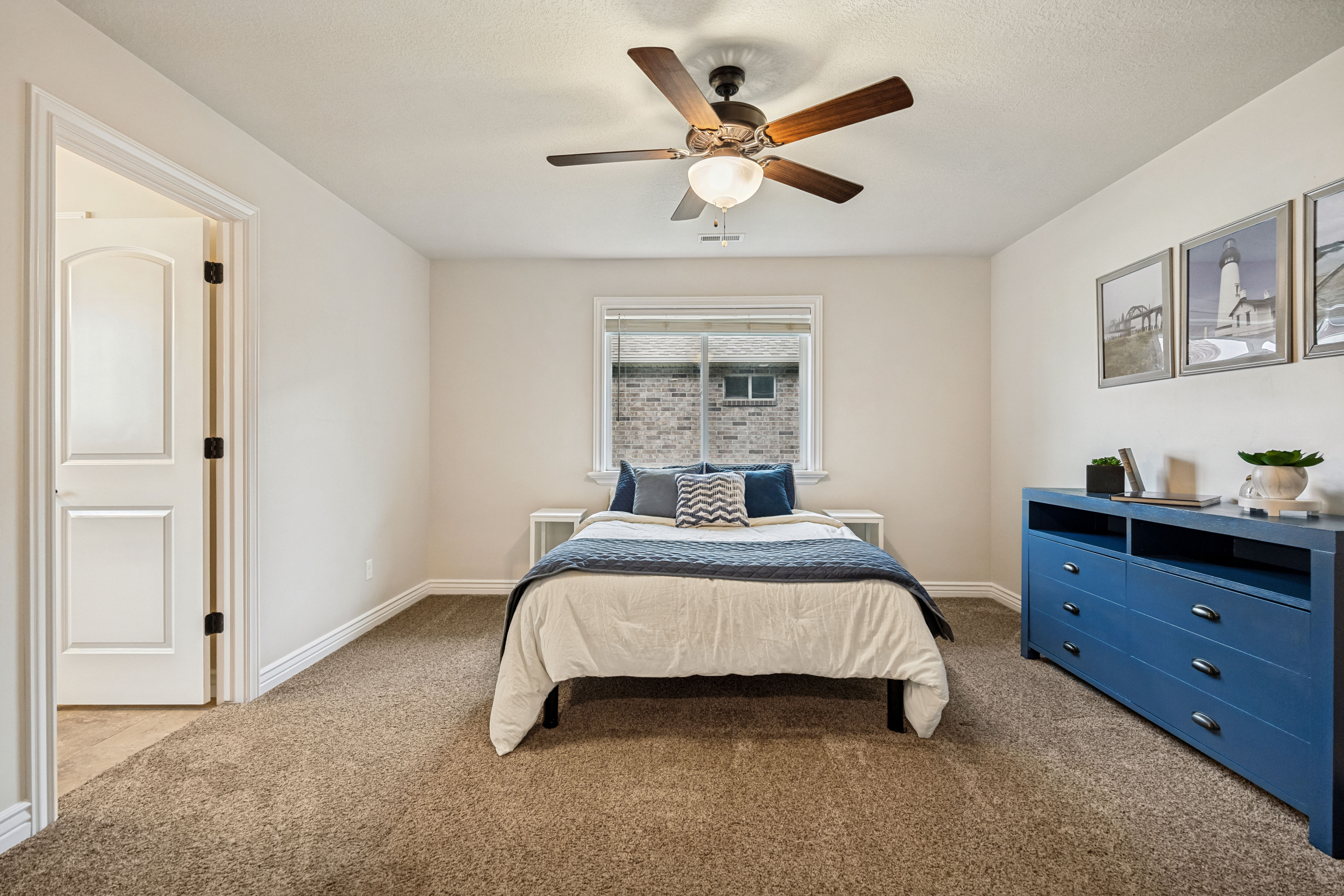 Carpeted room featuring a ceiling fan with light fixture, a window with white trim, and a paneled door