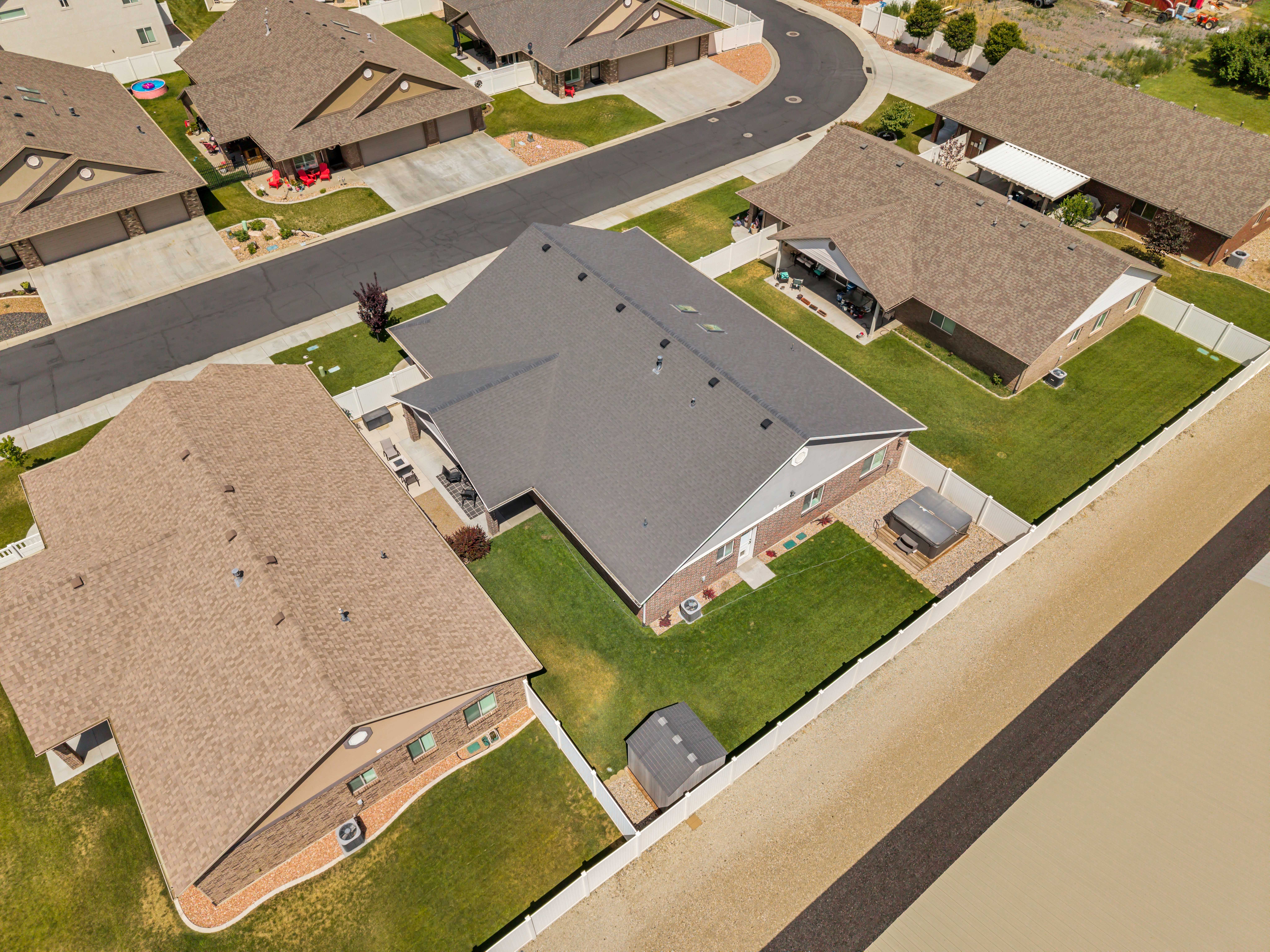 Single-story residence featuring a gray shingle roof and light gray siding with brick accents