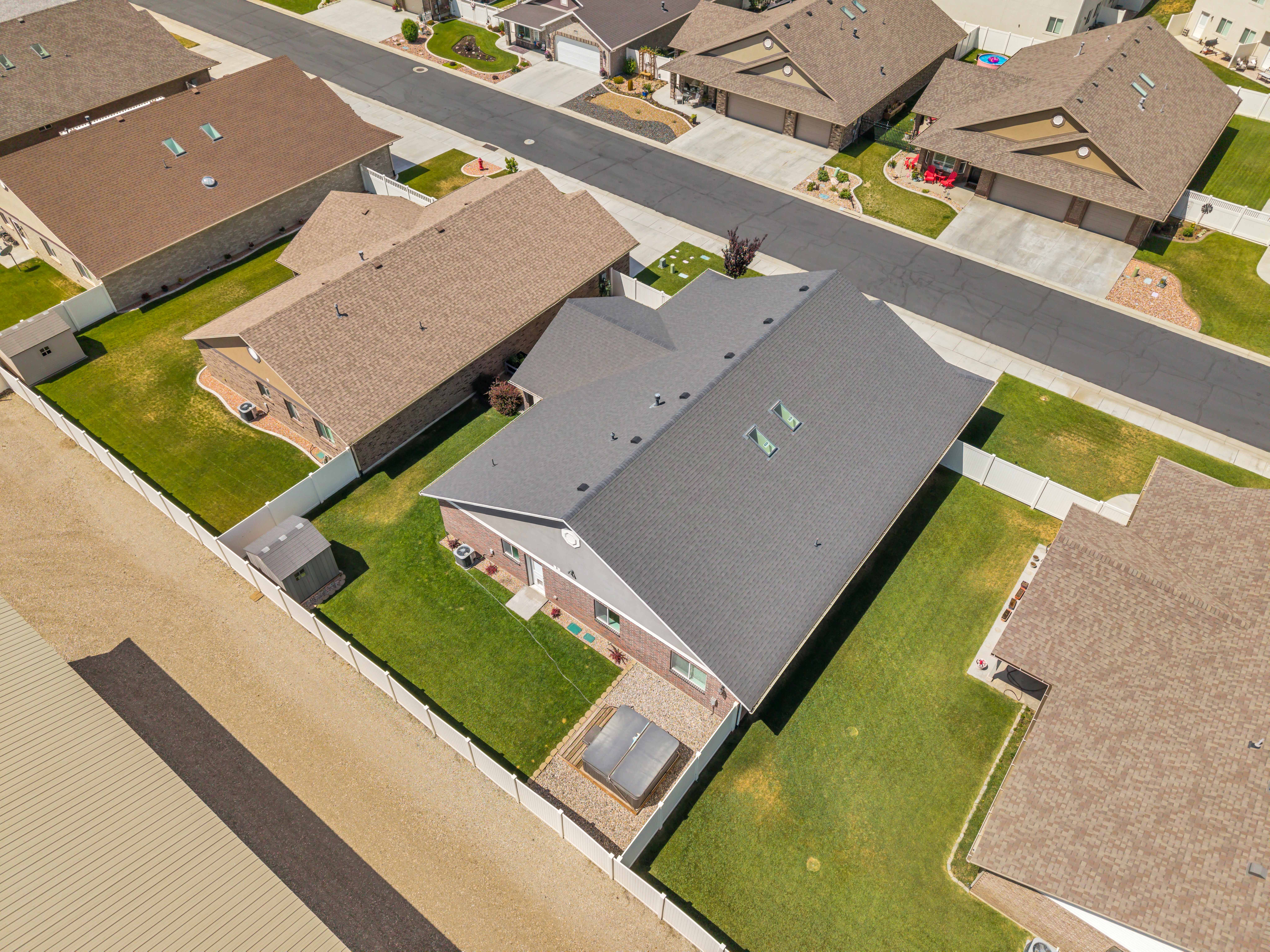 Aerial perspective showcasing a residential property with a dark shingle roof and brick siding
