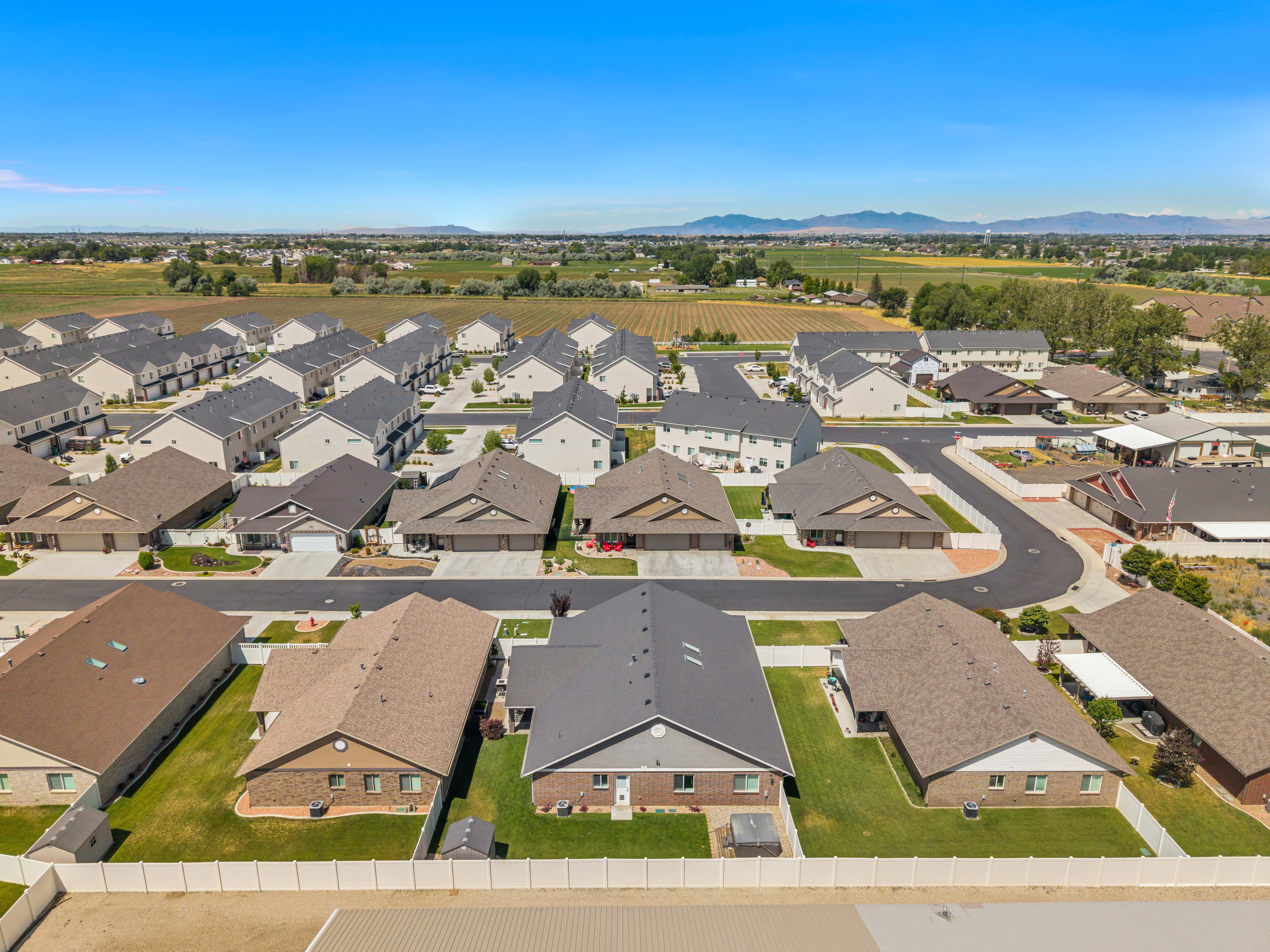 Residential community featuring a mix of single-story homes and multi-story townhomes with clear mountain backdrops