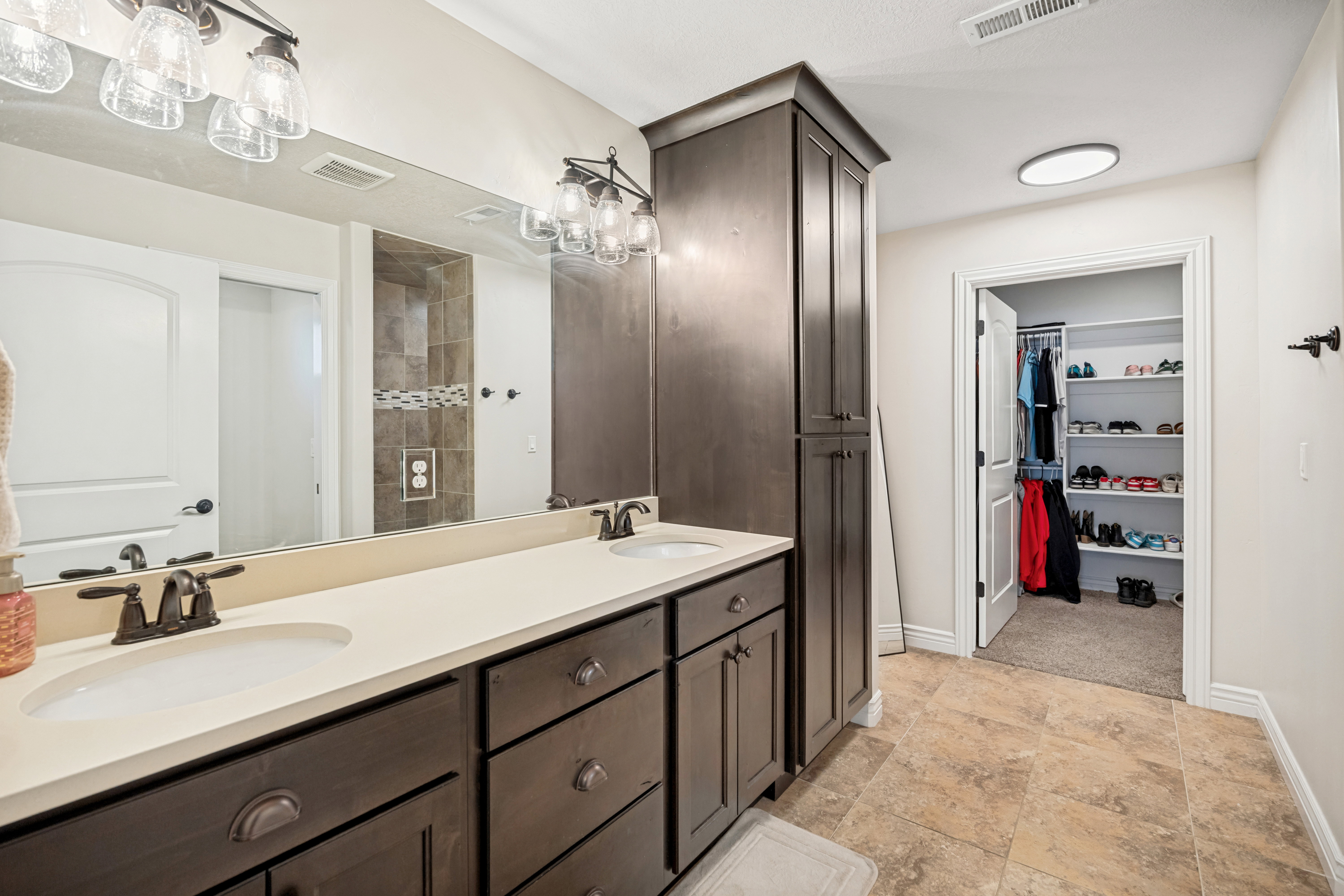 Double vanity with integrated sinks and dark wood-finish cabinetry