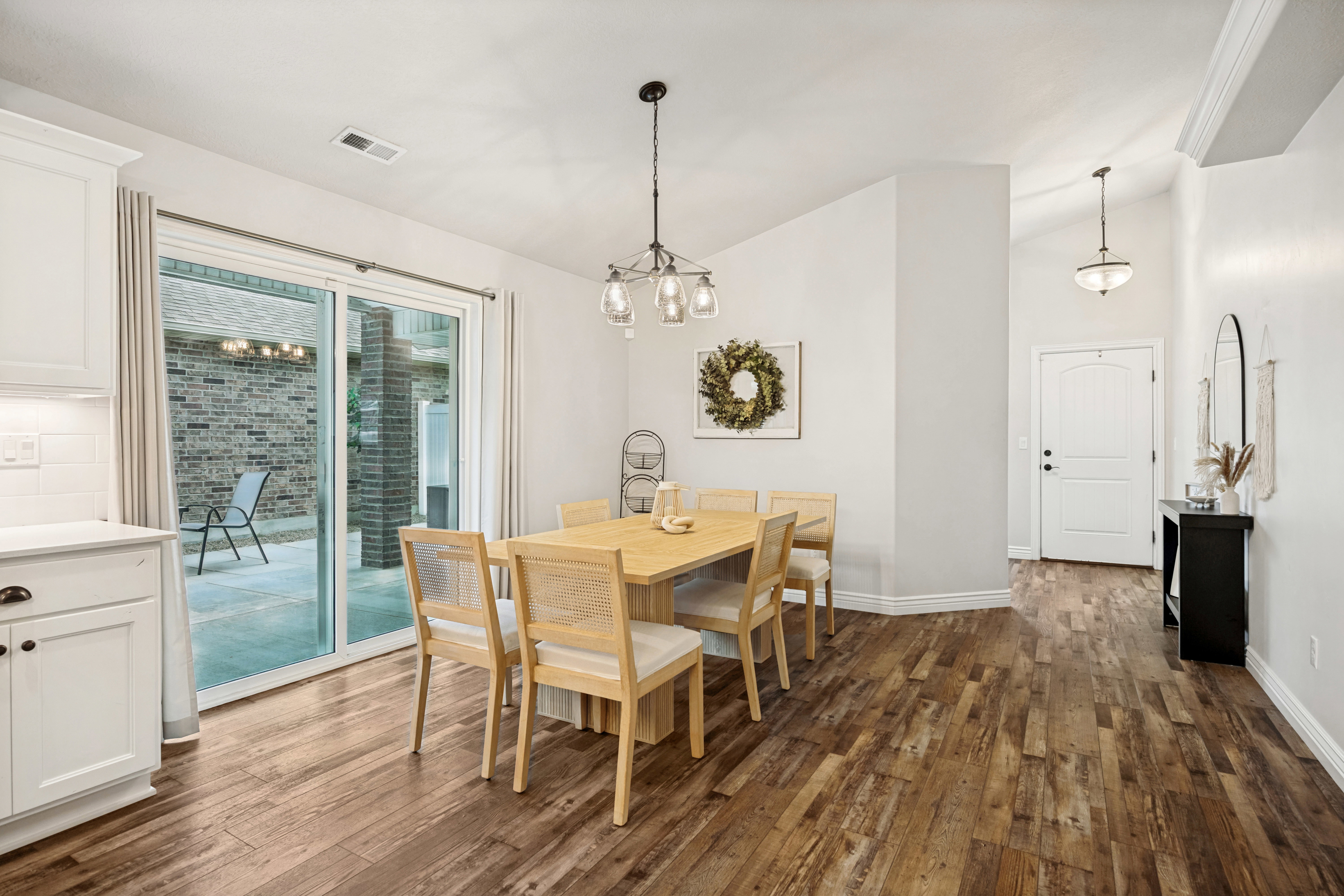Wood-finish flooring throughout, with a dining area featuring an overhead chandelier