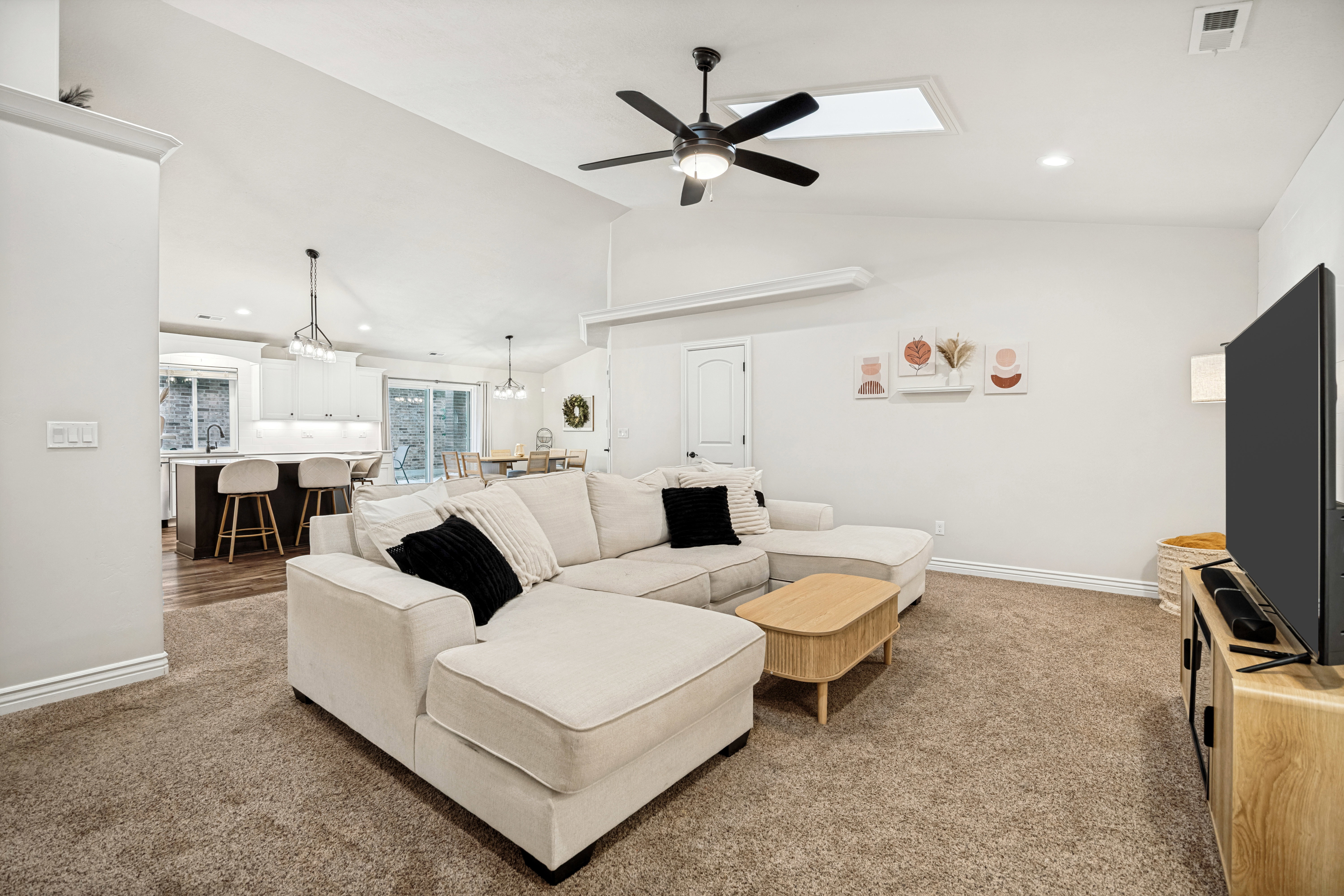 Spacious living area featuring vaulted ceilings, recessed lighting, and a modern ceiling fan