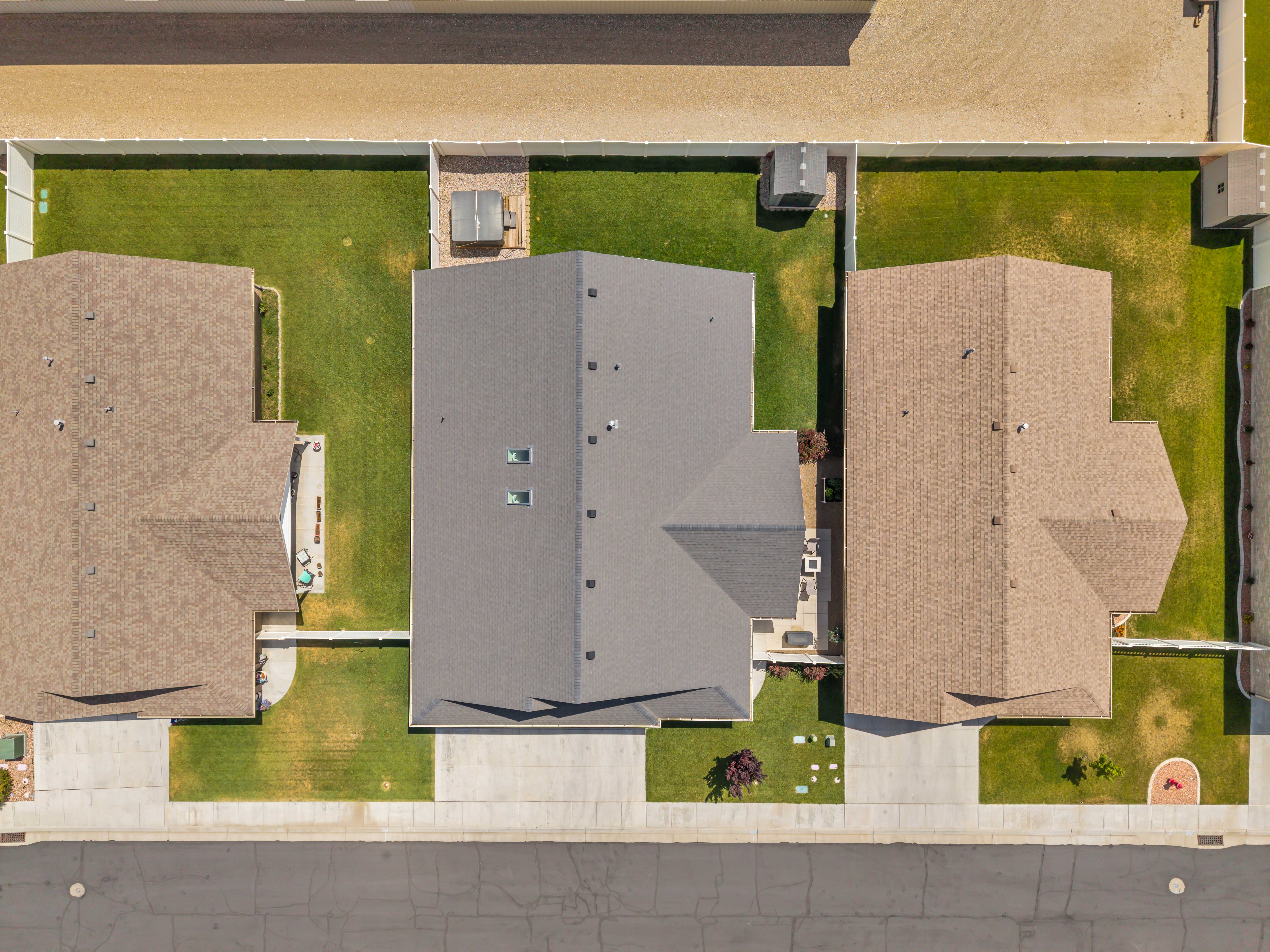 Aerial view of a residential property featuring a gray asphalt shingle roof with two visible skylights