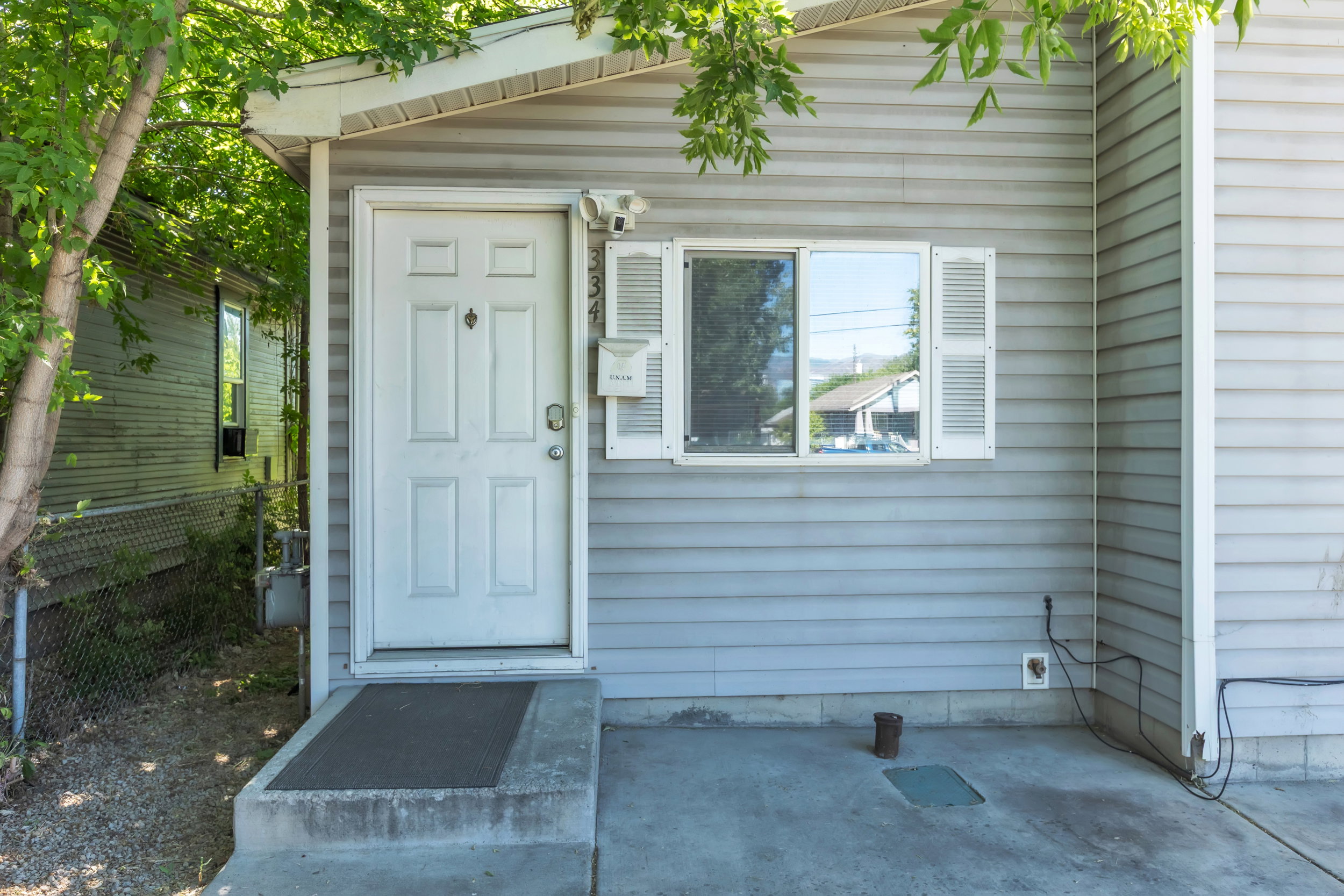 Gray horizontal siding exterior with a white paneled entry door
