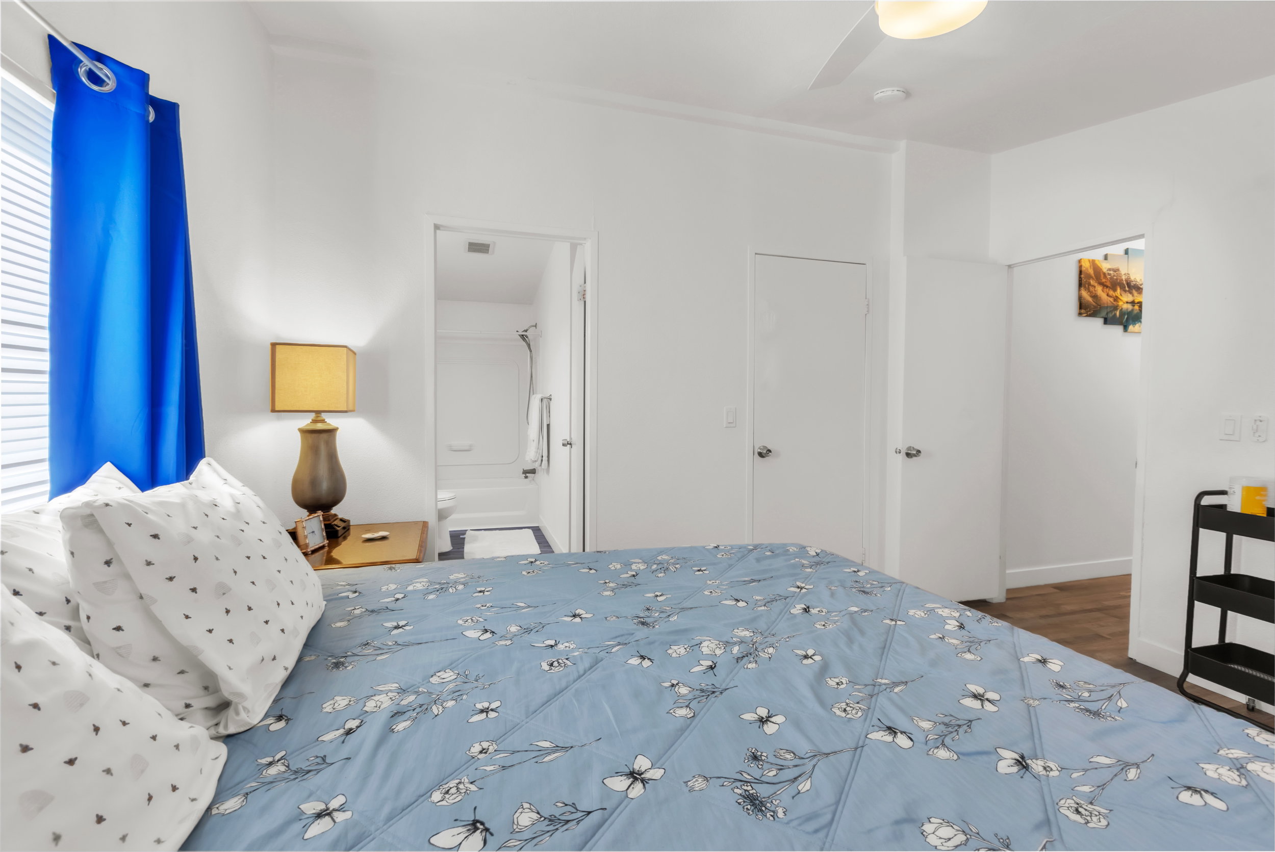 Bedroom featuring white walls, a ceiling fan with integrated lighting, and a window with blinds