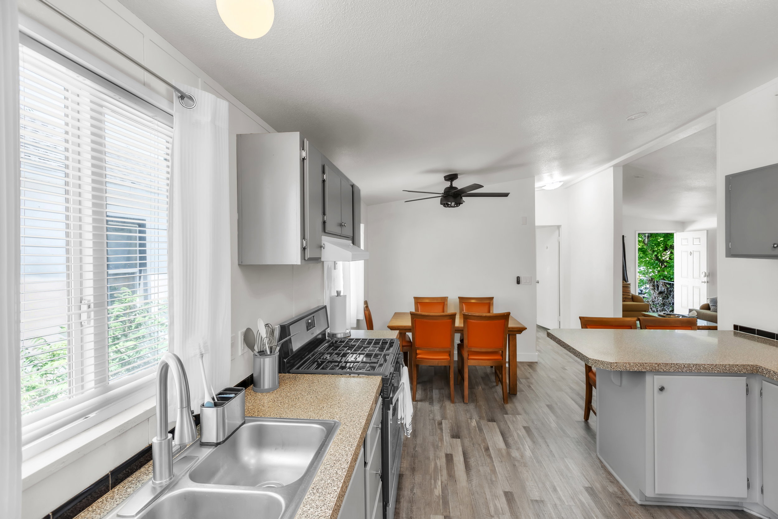 Kitchen featuring a stainless steel double basin sink, light-toned countertops, and wood-finish flooring