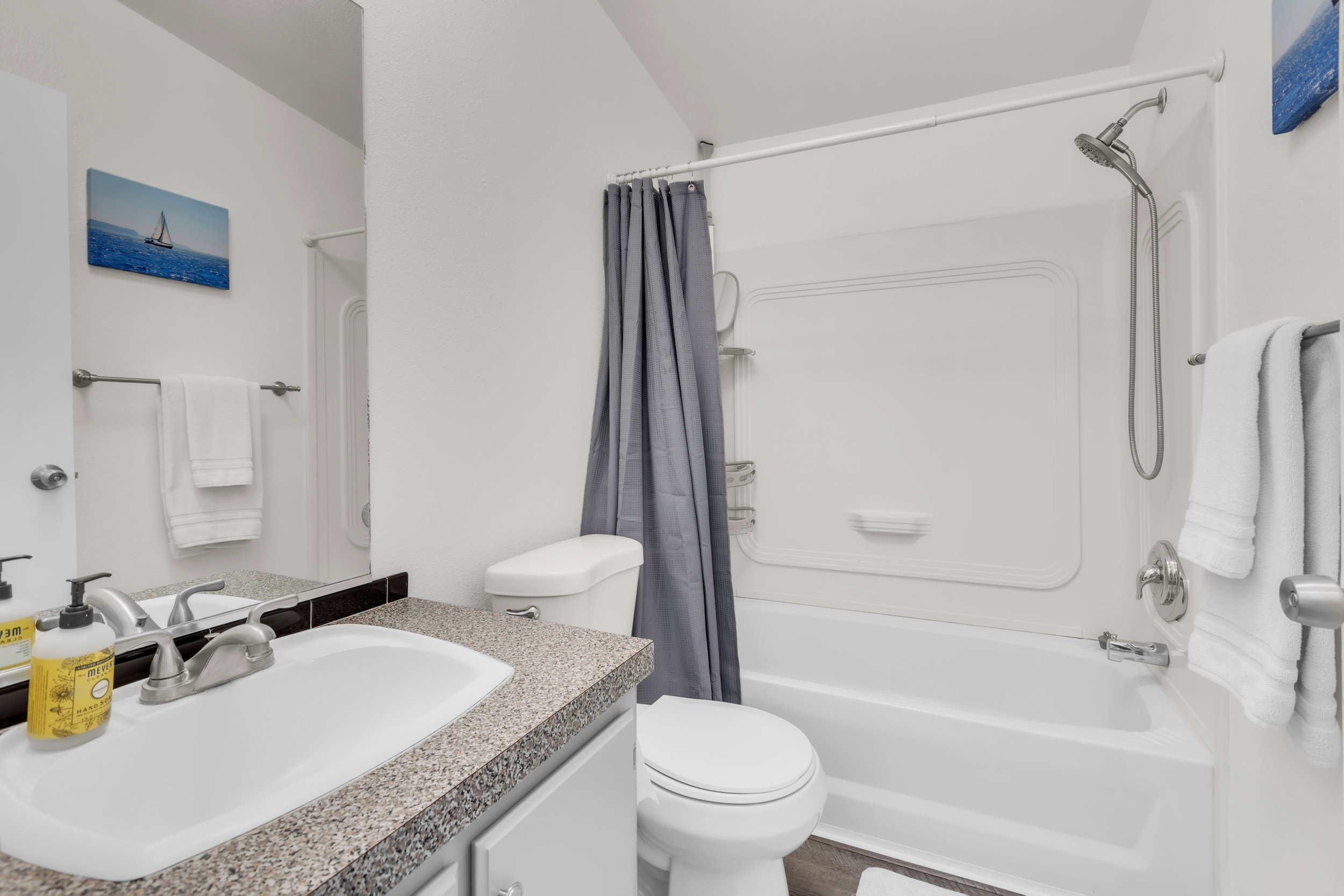 Bathroom featuring a single-basin vanity with a speckled countertop, an integrated sink, and a chrome faucet