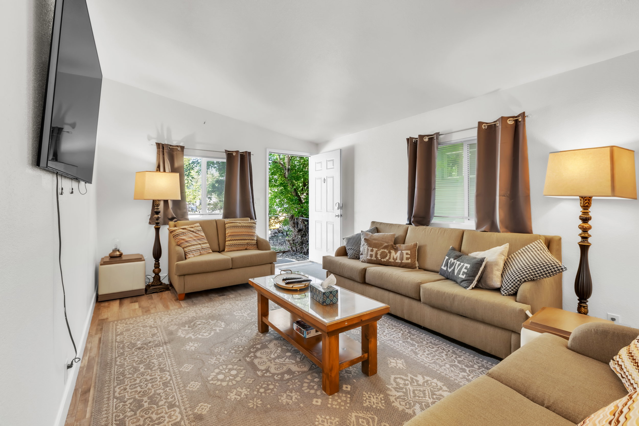 Open living area featuring wood-finish flooring and a central area rug