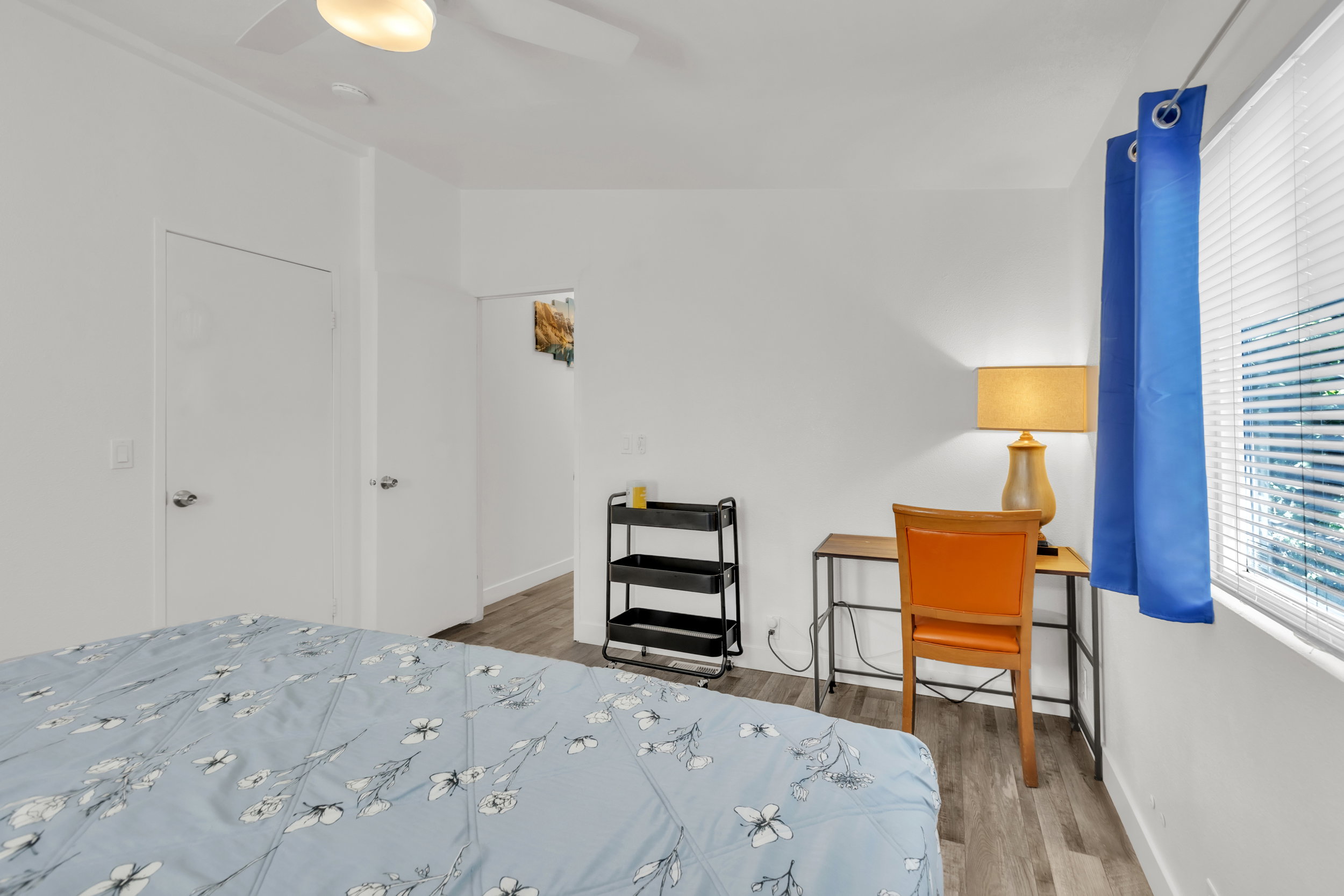 Room featuring light wood-finish flooring, white walls, and a ceiling fan