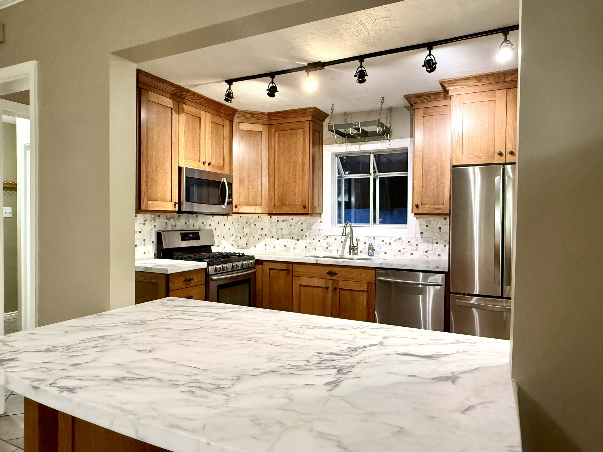 Kitchen featuring a spacious island with a marble-finish countertop