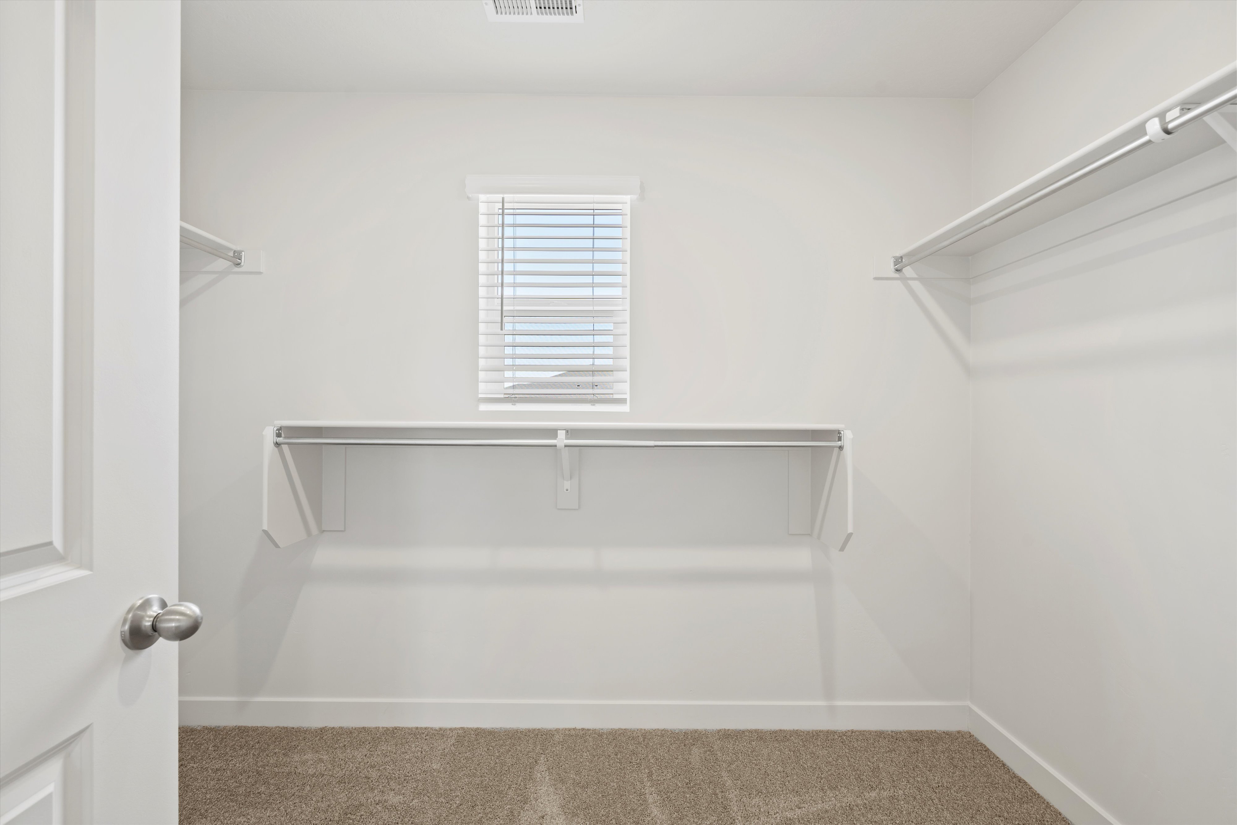 **DISCLAIMER** Interior package may vary. Walk-in closet with white walls, carpeted flooring, and a single window with horizontal blinds