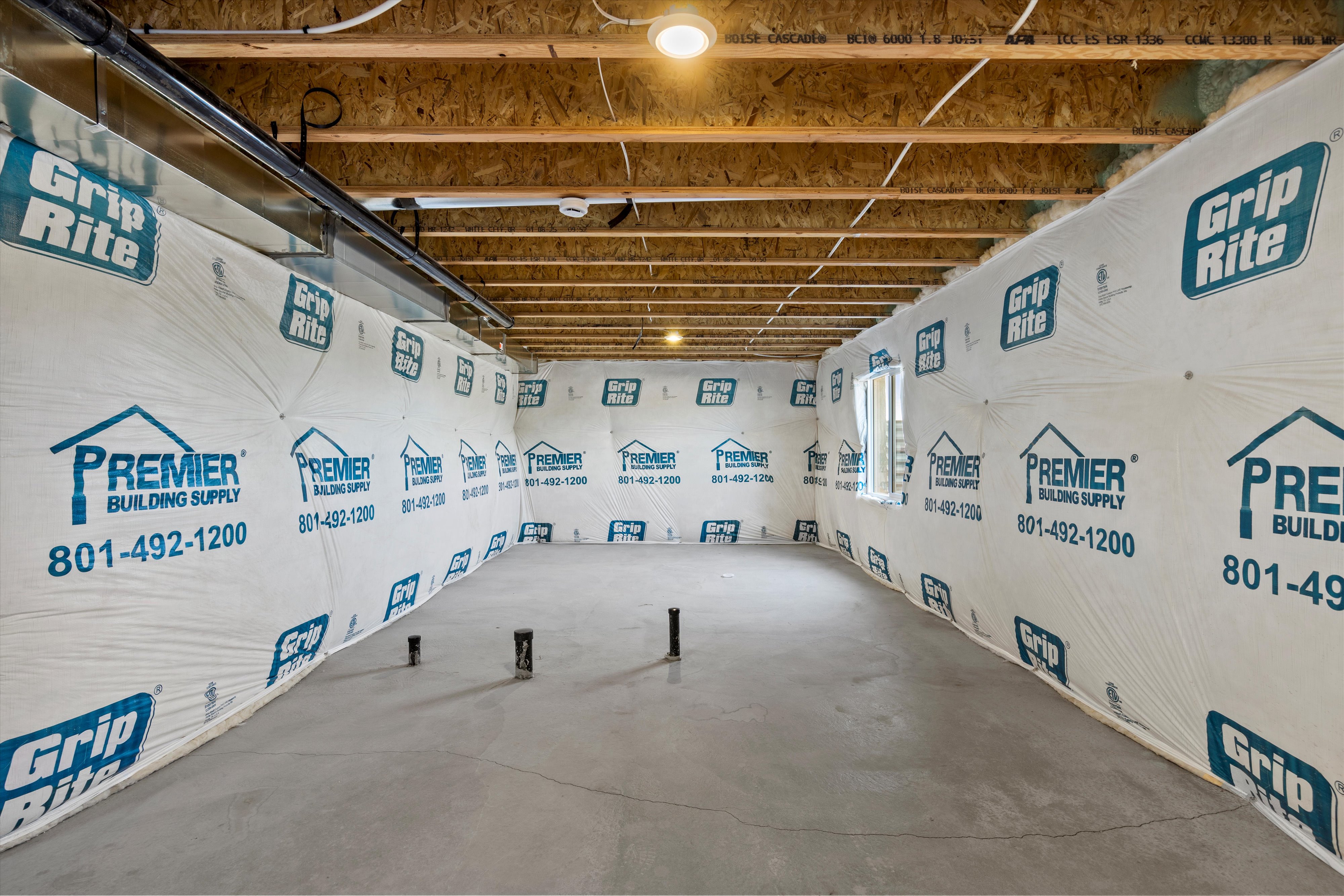 Unfinished basement with concrete flooring and perimeter wall wrapping