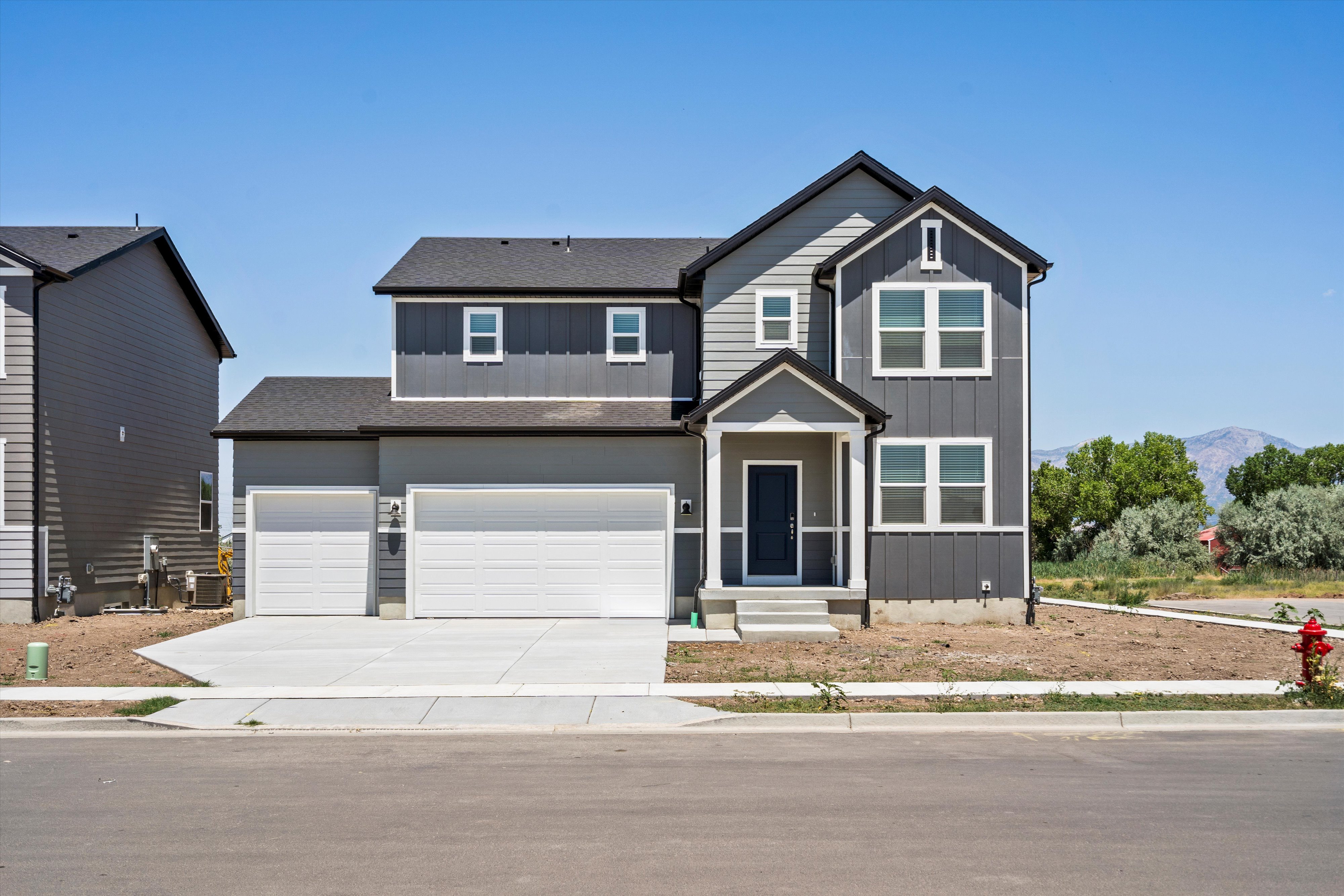 Contemporary two-story residence featuring a dark gray and light gray facade with vertical siding accents